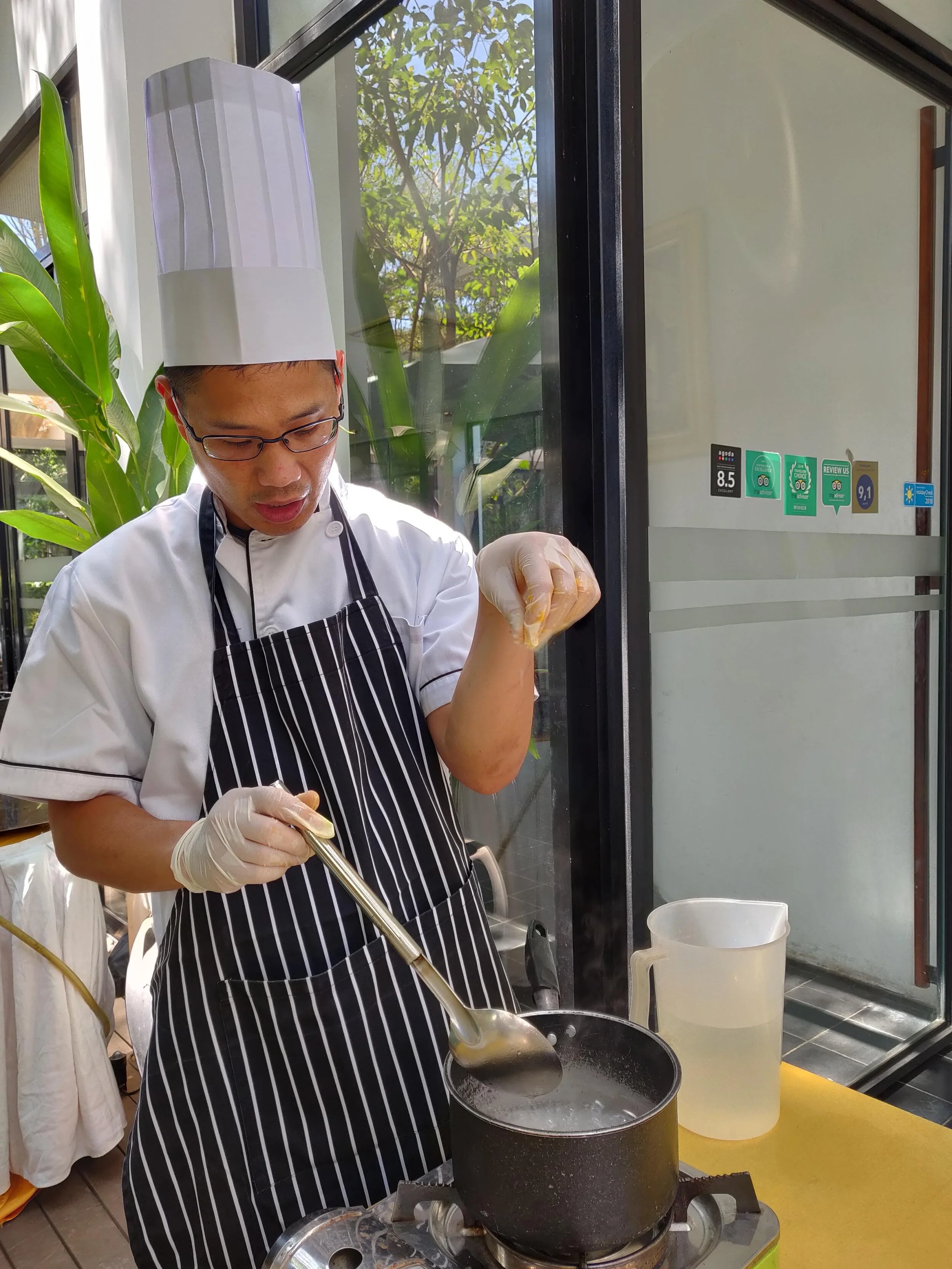 A pinch of salt for the Khmer tapioca-banana pudding. Siem Reap, Cambodia.