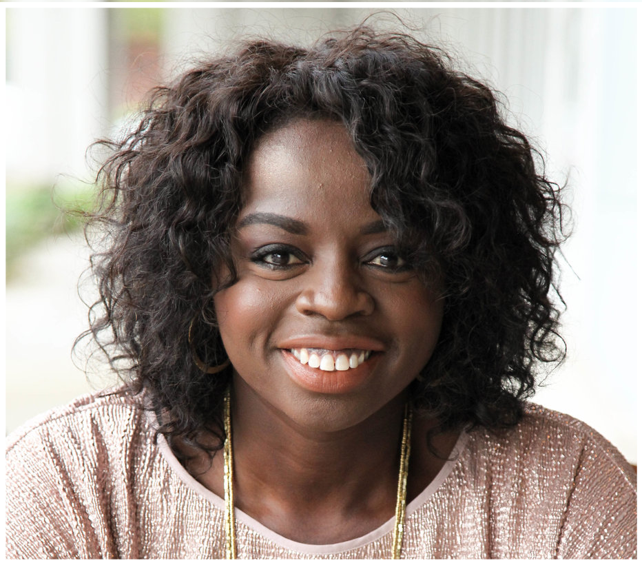 Headshot of Jo Saxton, a Nigerian-Londoner with short natural hair and a beautiful smile.