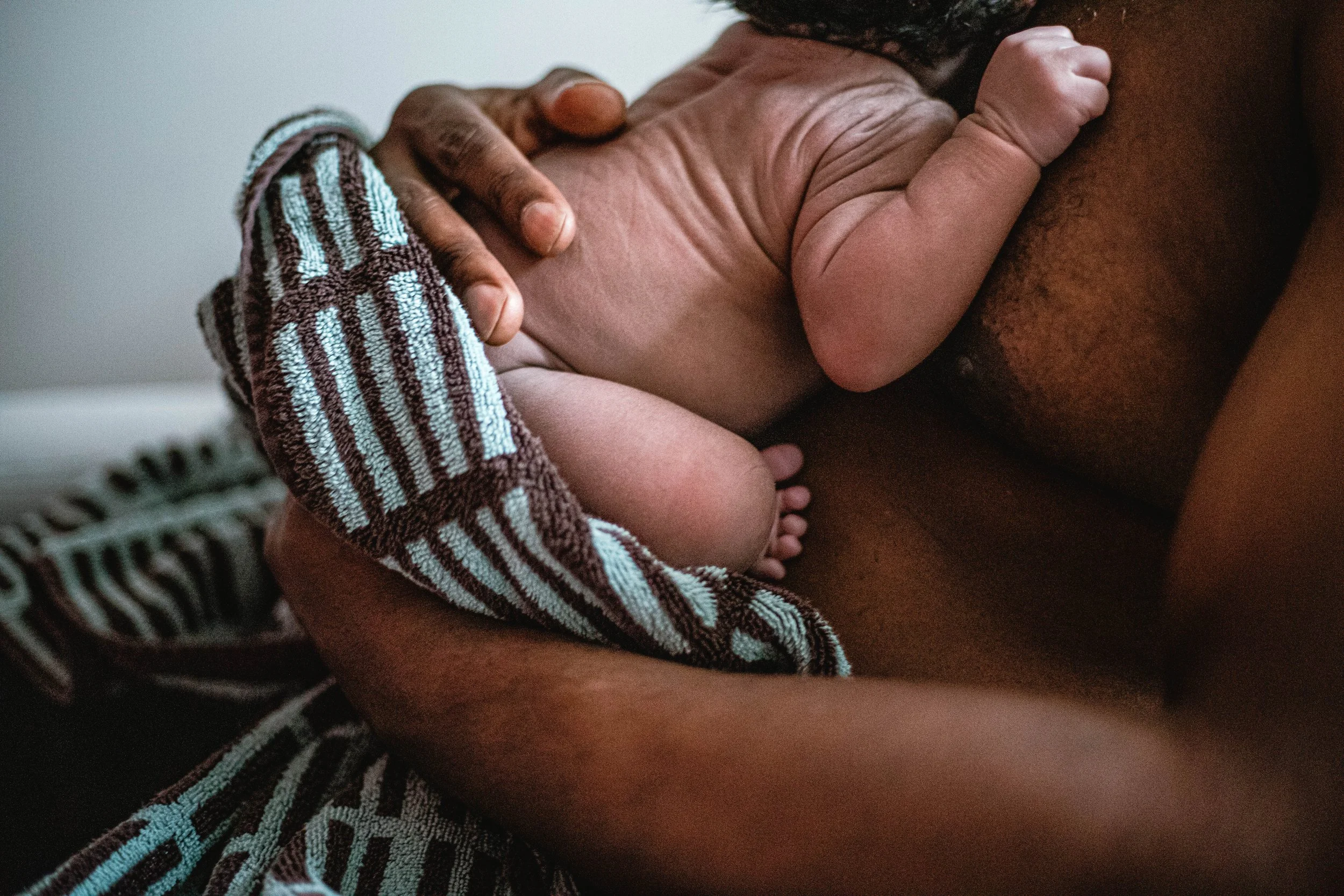 Father holds baby in his arms skin to skin