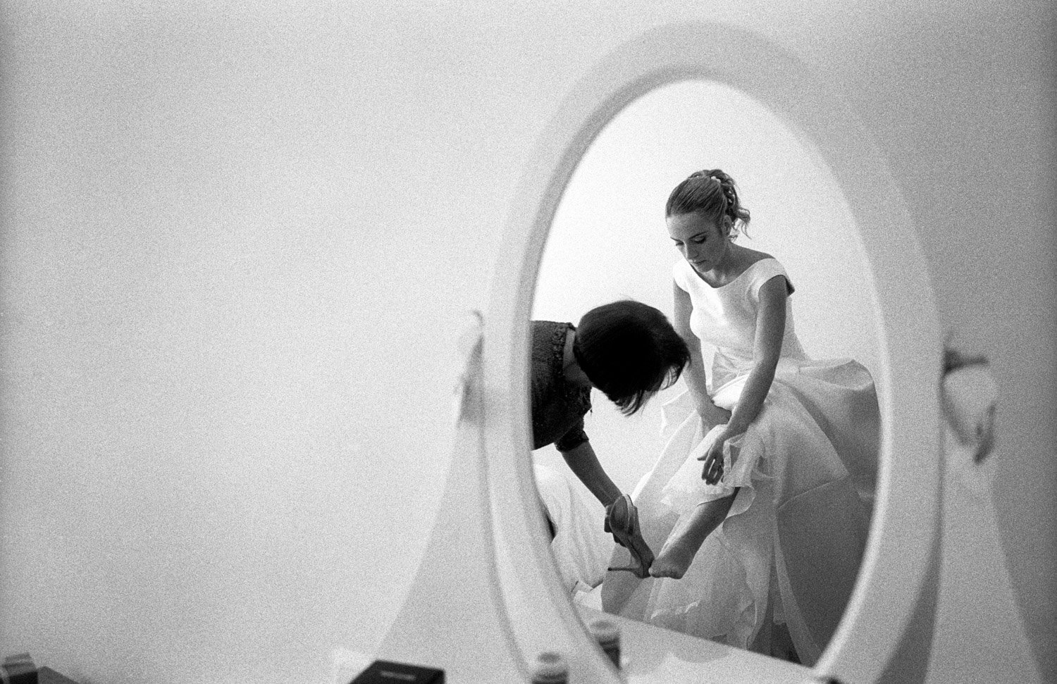 madre colocándole zapato a la novia. fotografía en film