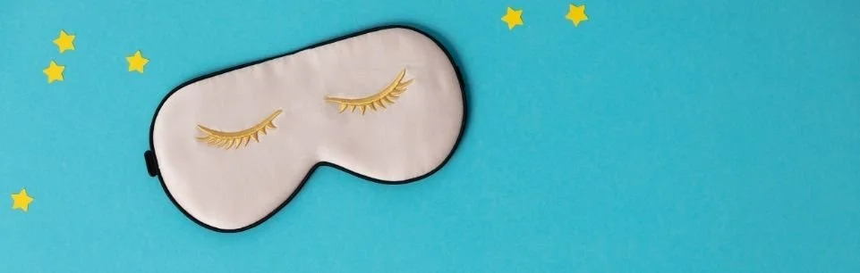 Sleep mask on blue background representing ADHD sleep struggles, insomnia, and the battle to leave the couch for bed