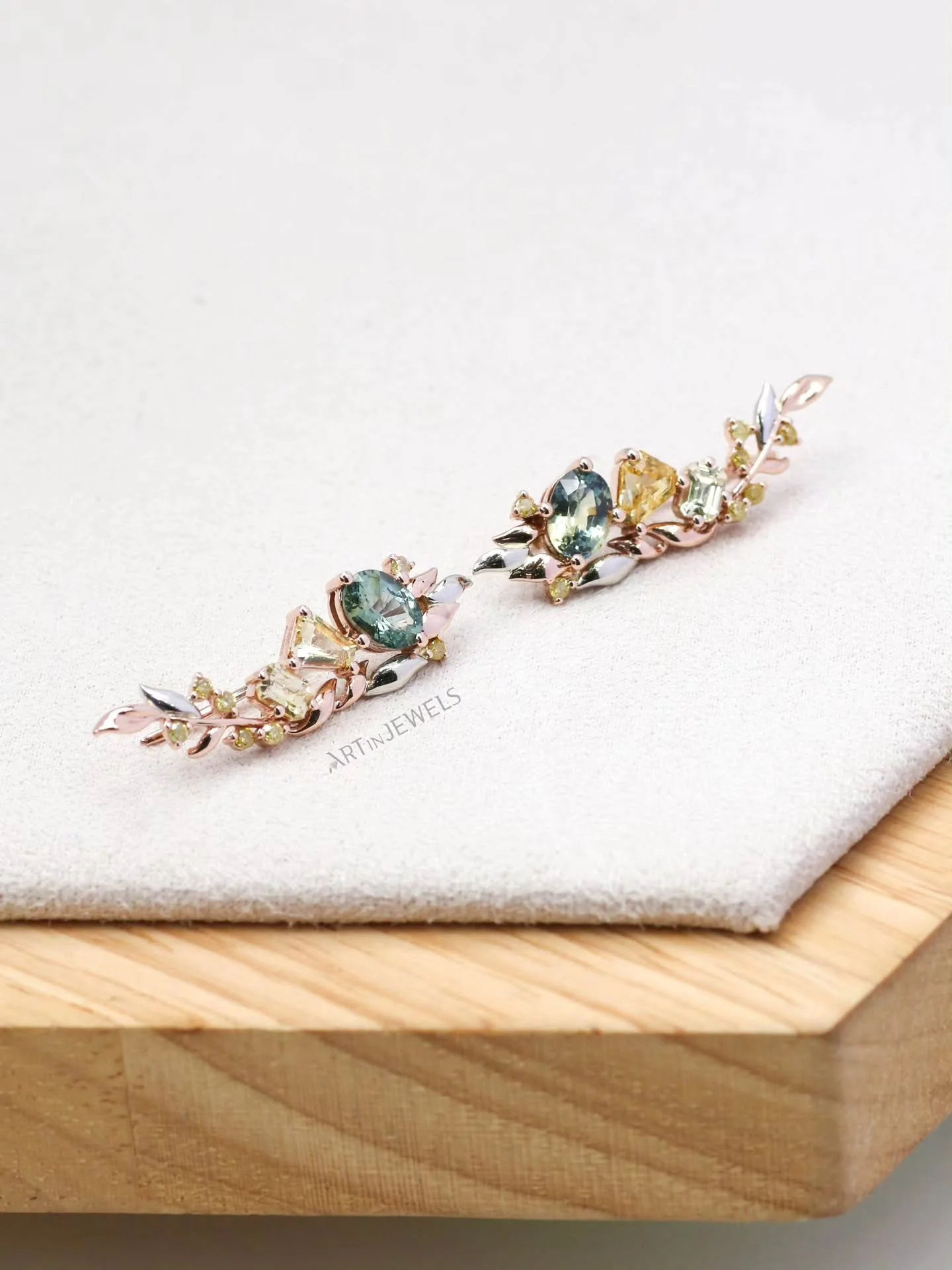 It's a nice, balmy afternoon. The wind blows gently. Under the shade of your favorite tree, the leaves are rustling.

We accentuated E's parti sapphires with natural yellow sapphires and diamonds to bring out their distinct character. Layers of rose 