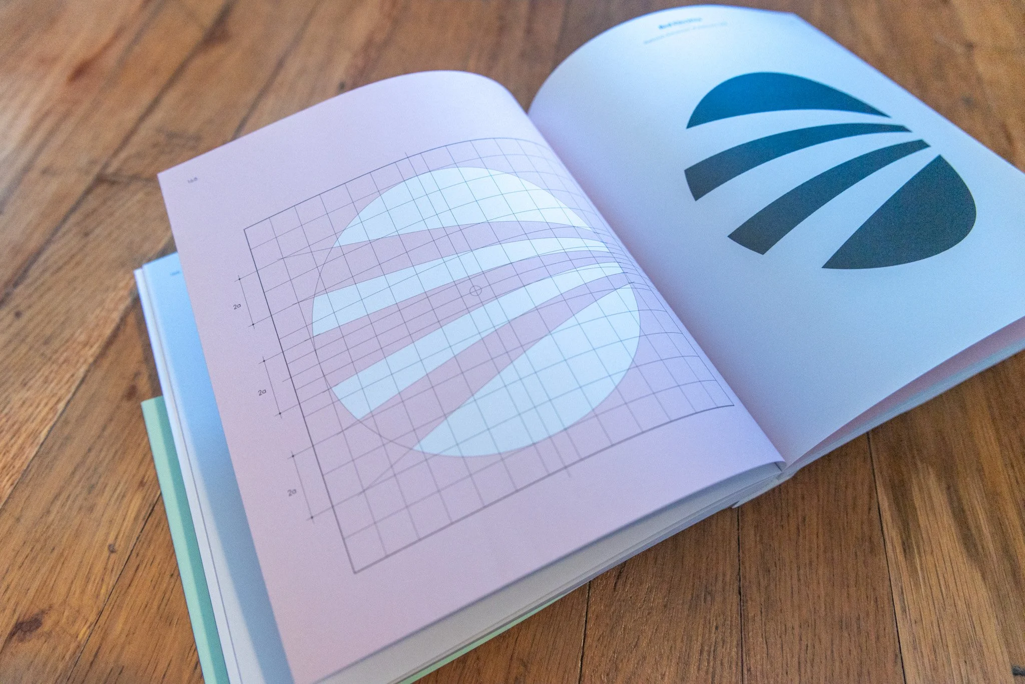 Open spread from Cruz Novillo: Logos showing a logo construction grid beside a completed circular mark, illustrating José María Cruz Novillo’s precise geometric approach to identity design.