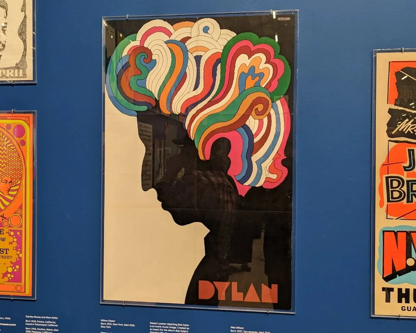 Poster of Bob Dylan featuring a black silhouette profile with colorful, swirling psychedelic shapes forming the hair against a light background.