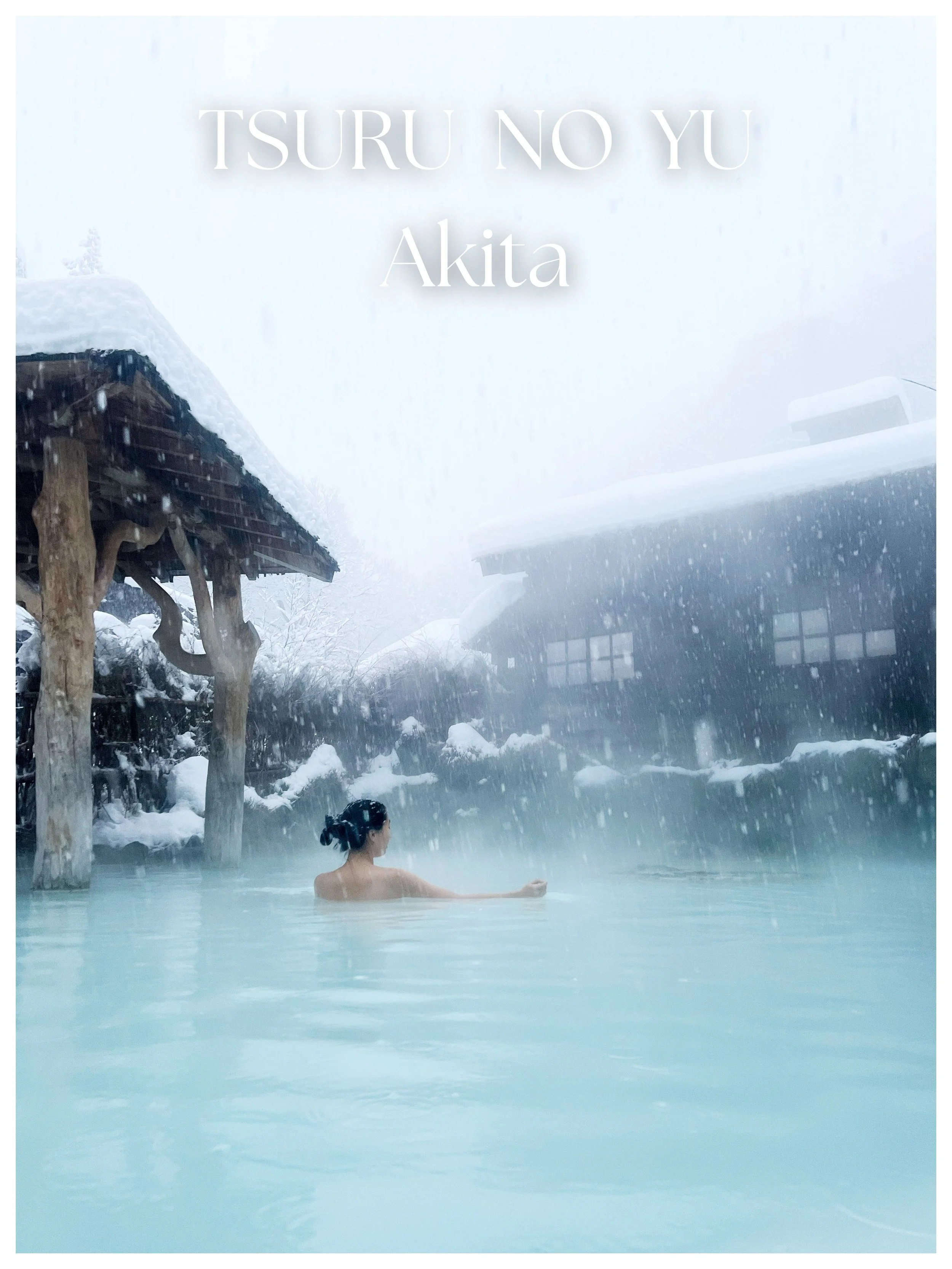 A woman relaxing in an outdoor hot spring with snow falling, traditional Japanese wooden buildings in the background, and snow-covered trees.