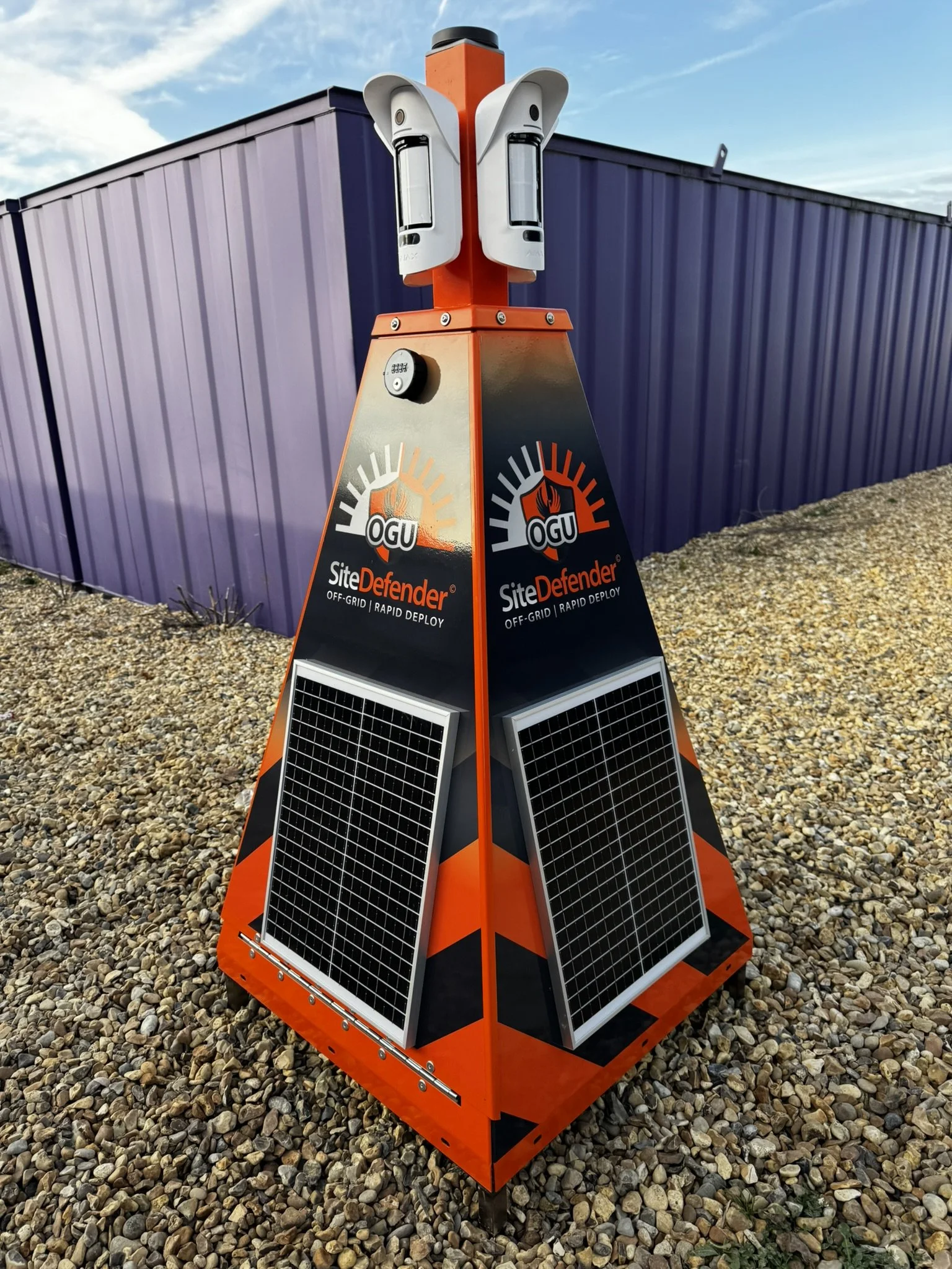 A portable off-grid solar-powered cctv tower labelled SiteDefender and solar panels on the sides.