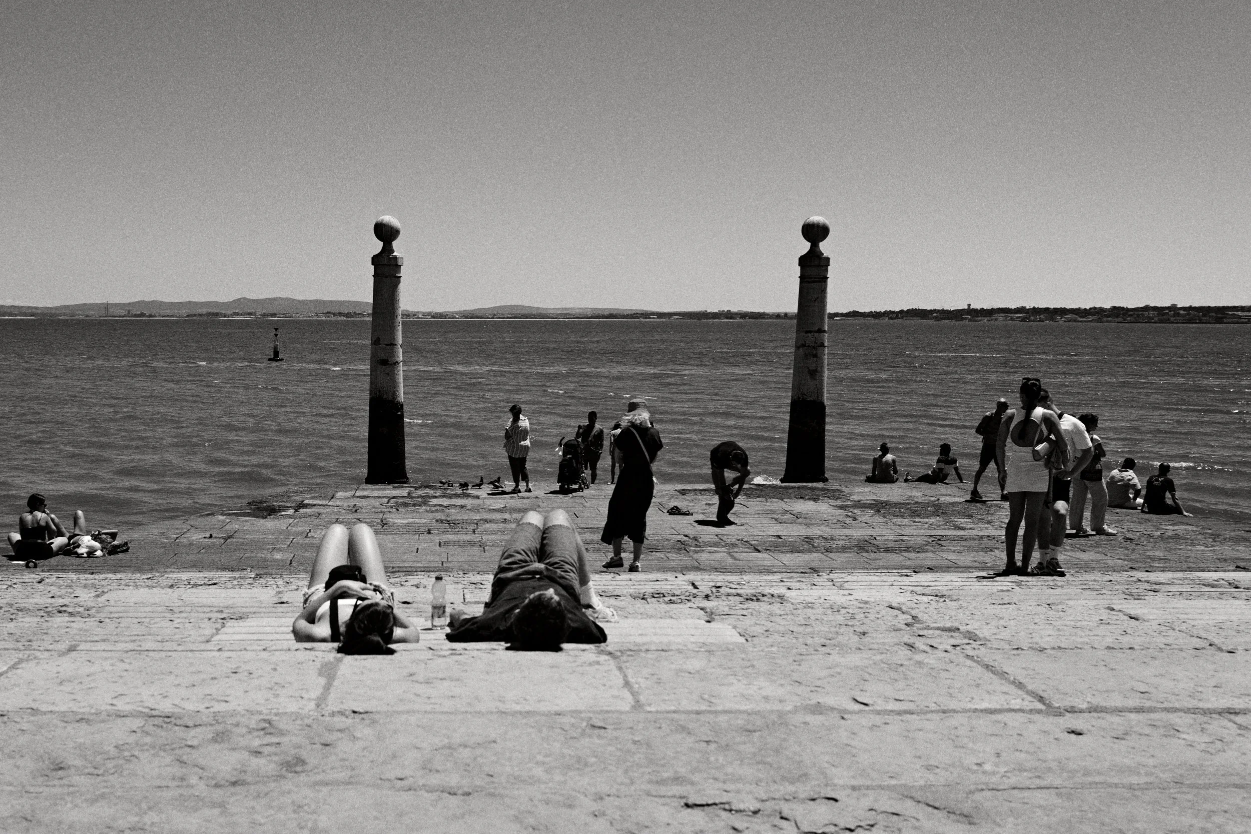 Black-and-white Leica street photo from Interwoven Cities by John Hendrick—urban life in contrast.