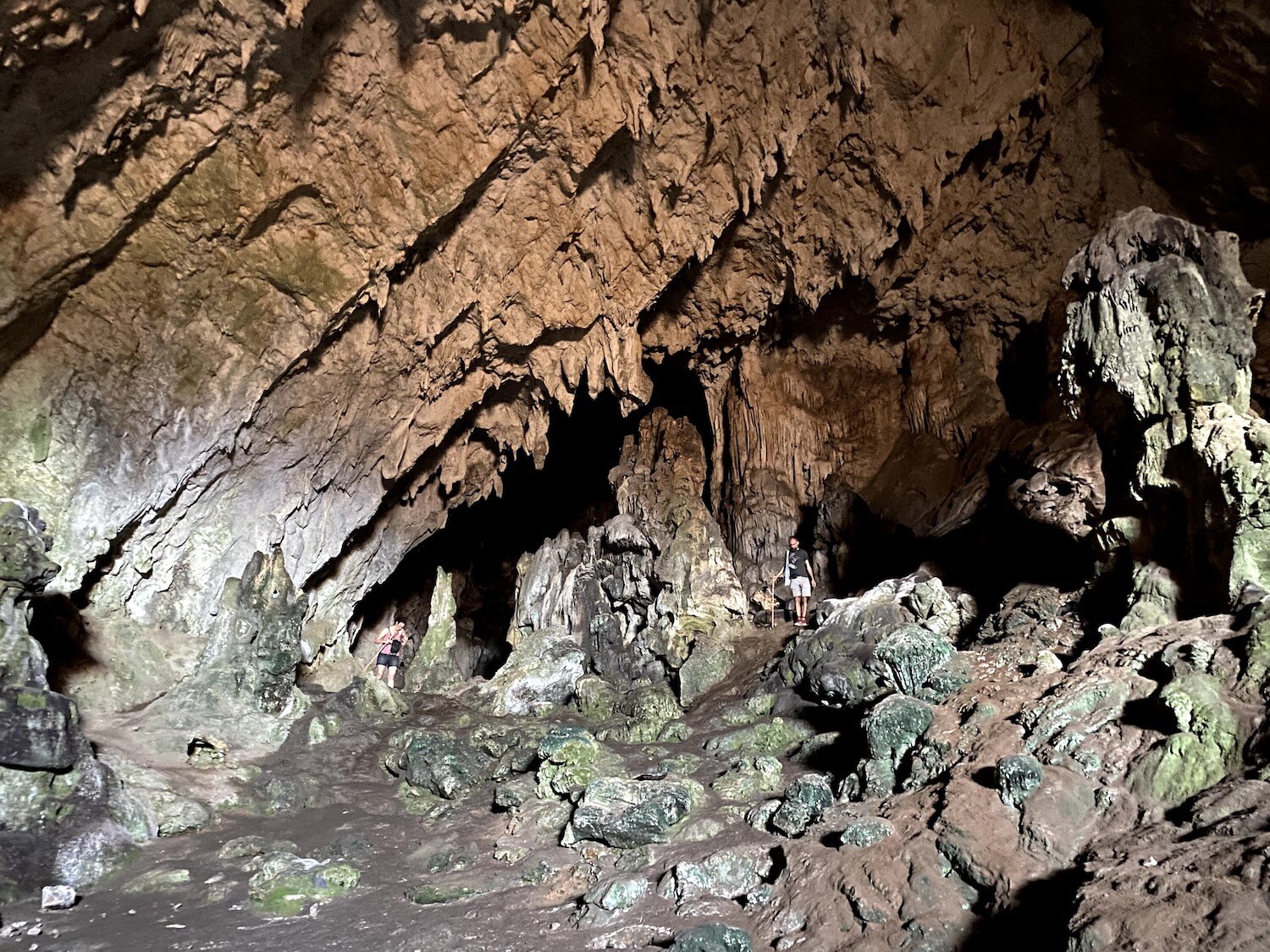 A photograph of the interior of the Corycian Cave, with me and my partner appearing so small we seem to be blending into the rock formations. Photograph taken by Erin Bernstein.