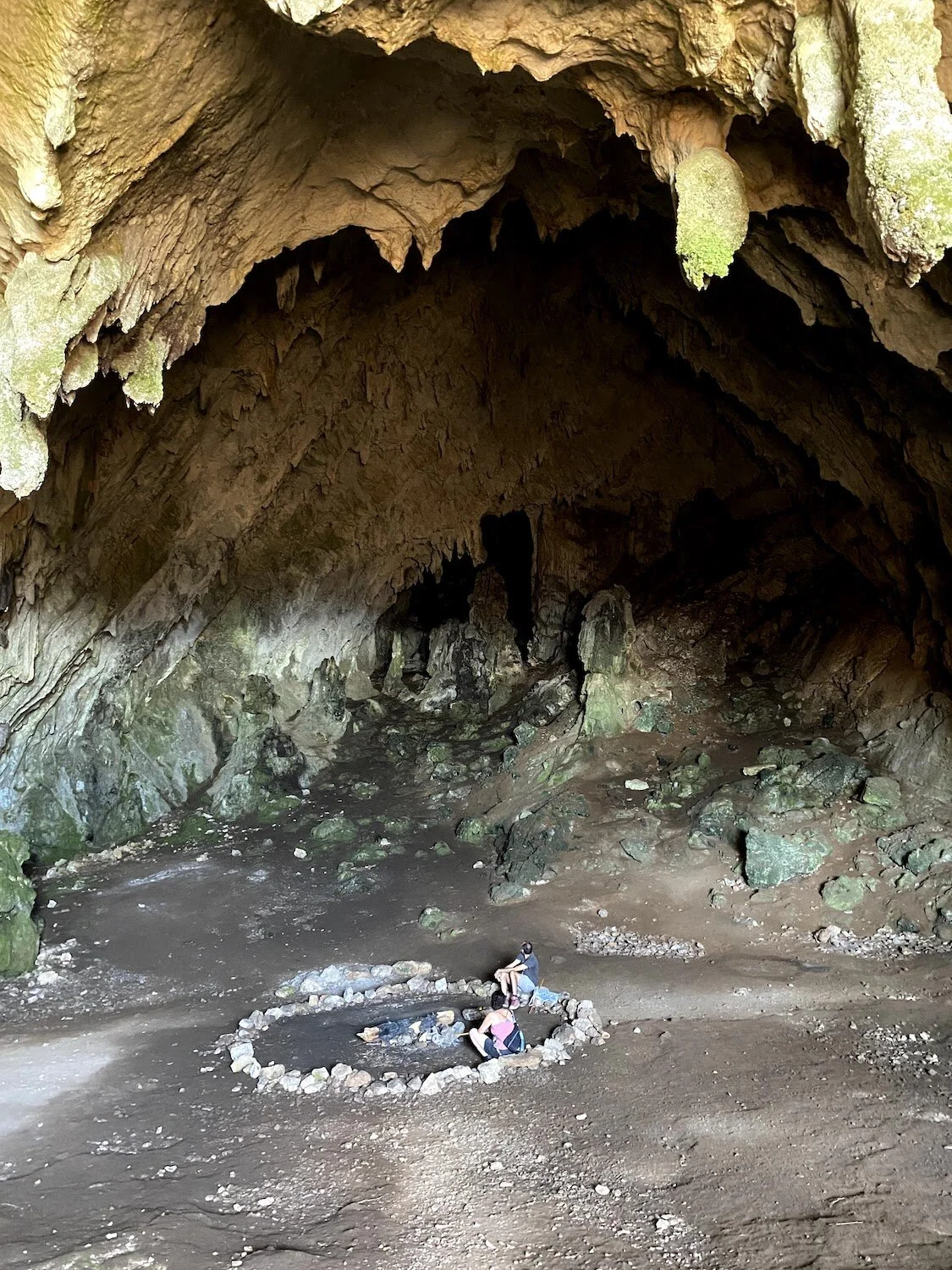 A photograph taken from the entrance of the Corycian Cave, showing the stone circle where I sit with my partner around an extinguished fire. Photograph taken by Erin Bernstein.