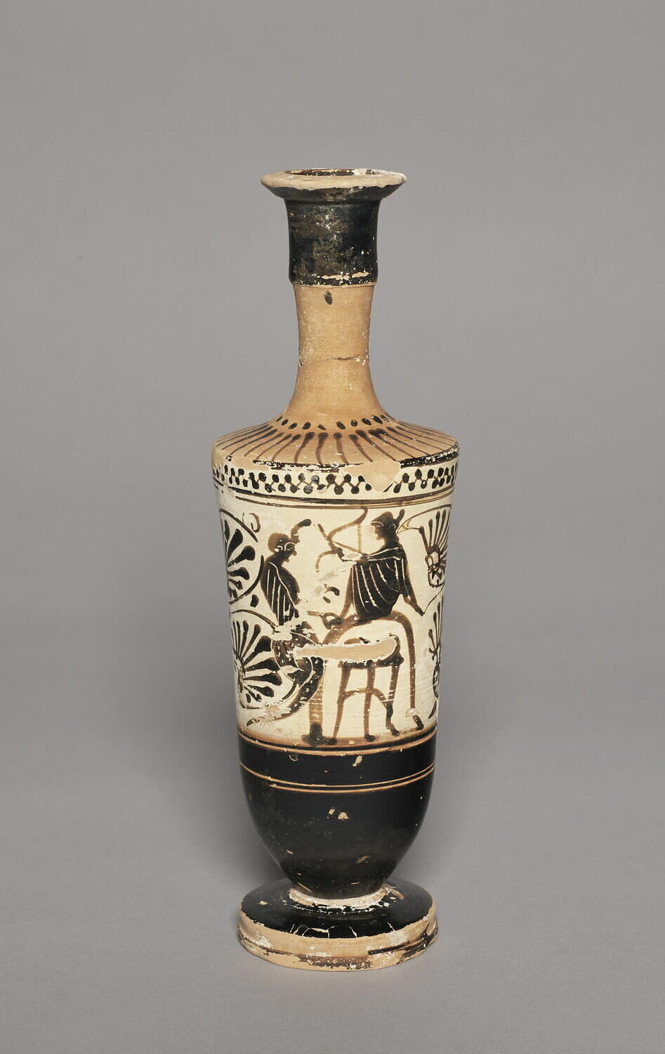 A black figure lekythos depicting Apollo possibly seated upon the Omphalos (containing a tripod) and facing the serpent dragon of Delphi. Via the Louvre accessed on 6 October 2021.