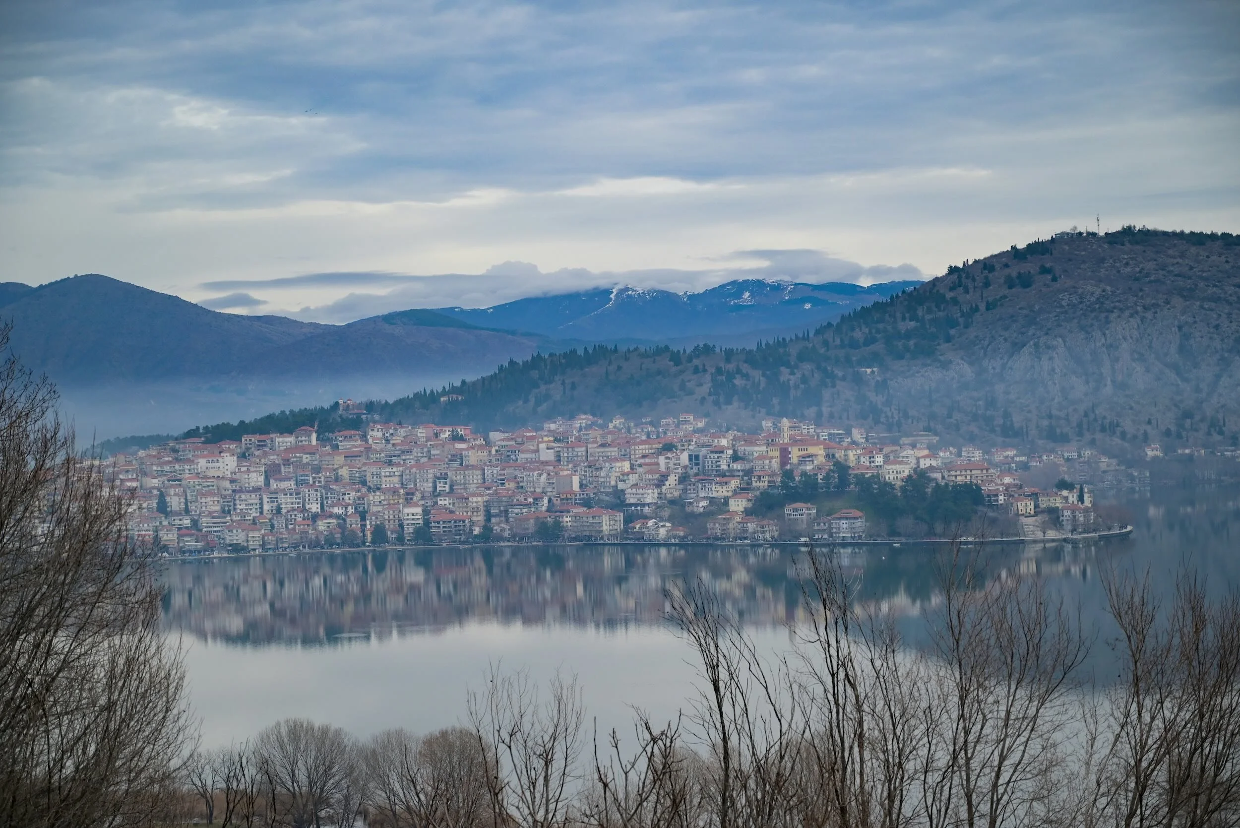 A town of houses beside a lake with the mountains in the background