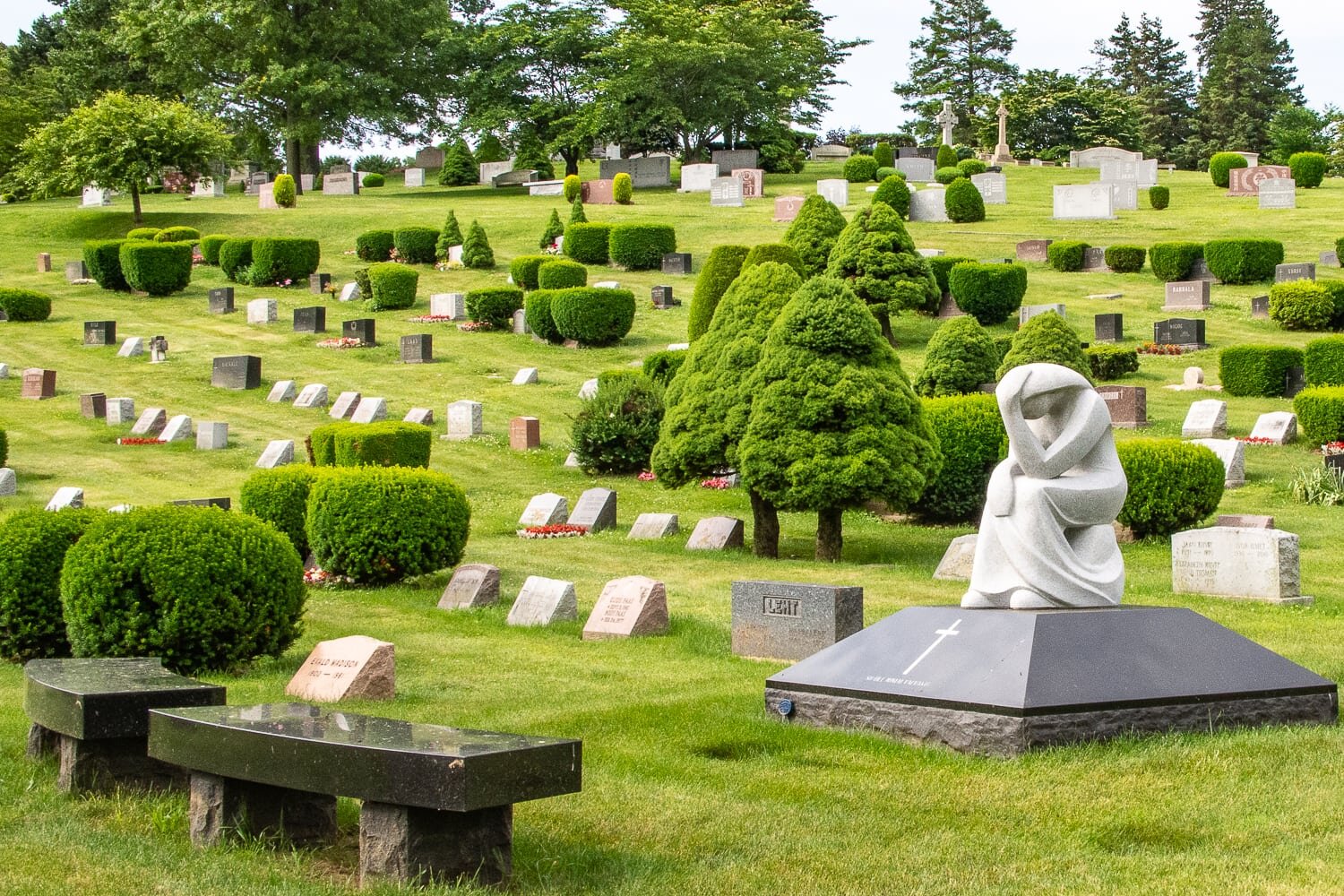 modern cemetery landscape with grieving sculpture