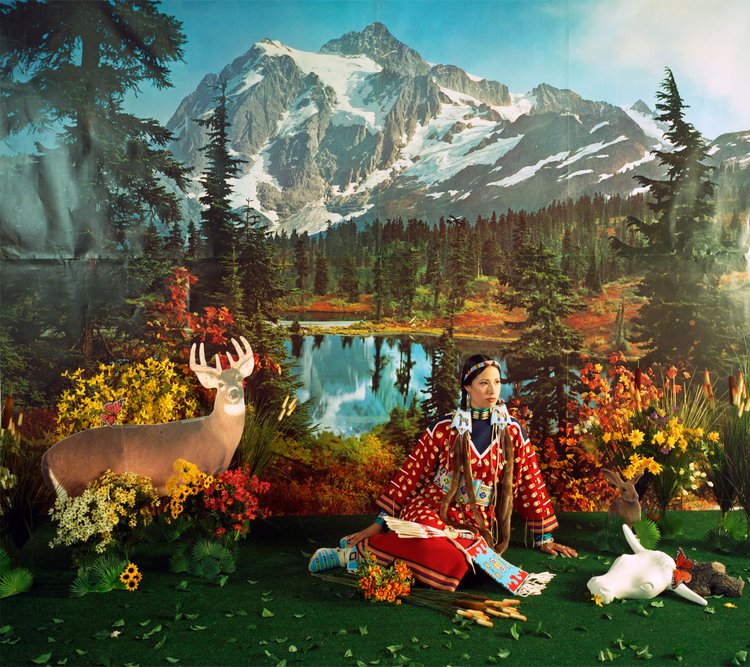 Native American art showing a woman sitting in a nature background next to a picture of a deer.