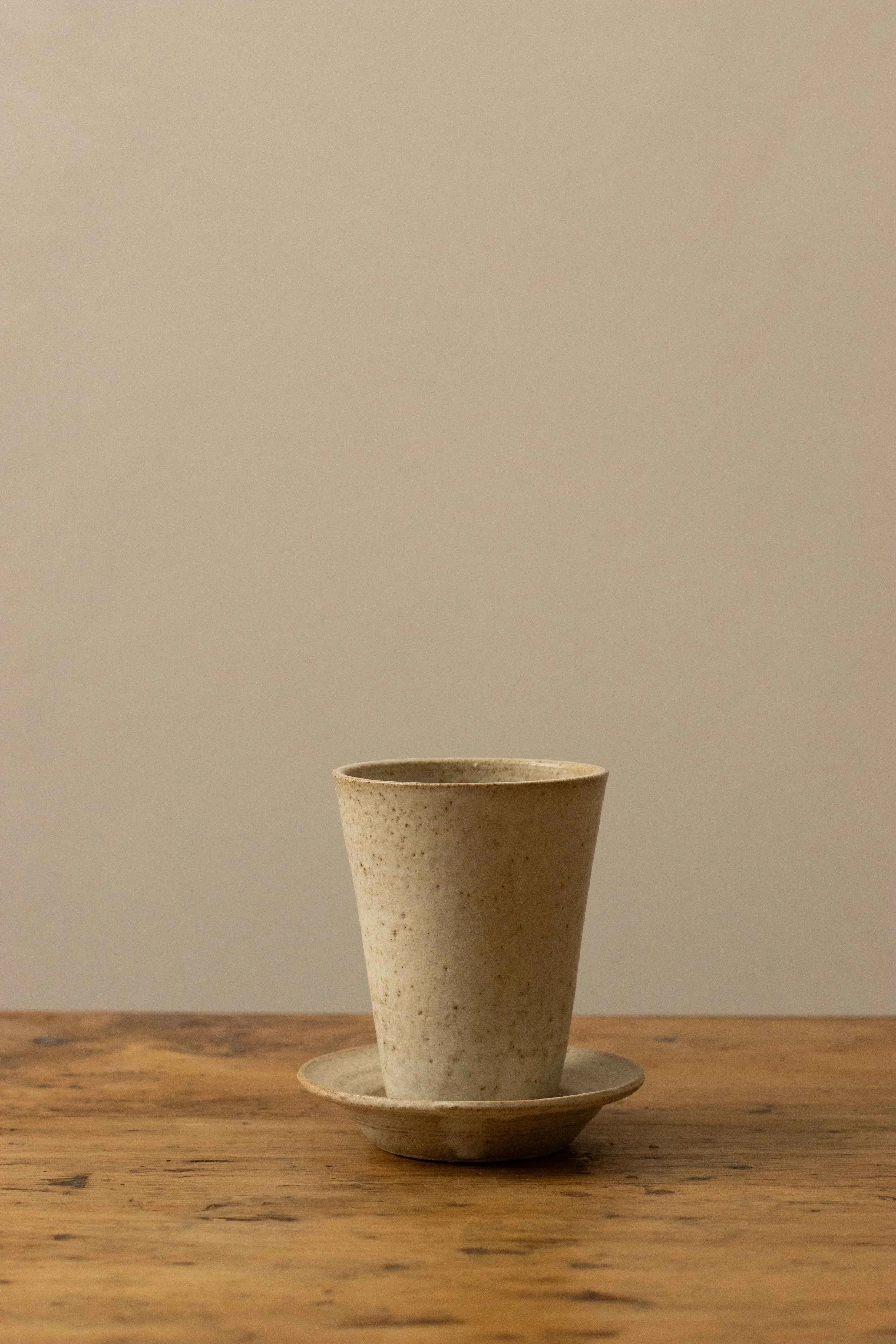Tall cup and saucer in stone