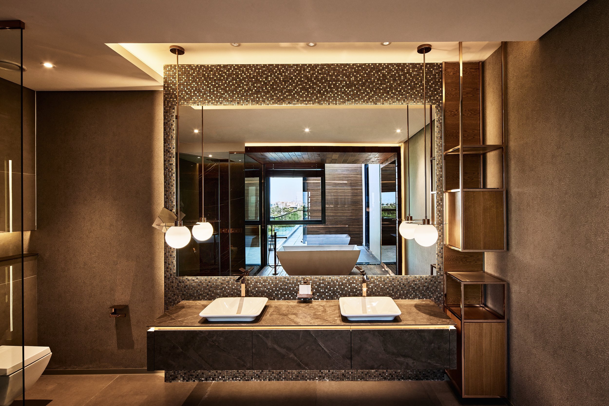 Bathroom vanity with twin basins, pendant lights and a pebble-mosaic wall, M Villa, Dubai Hills Estate