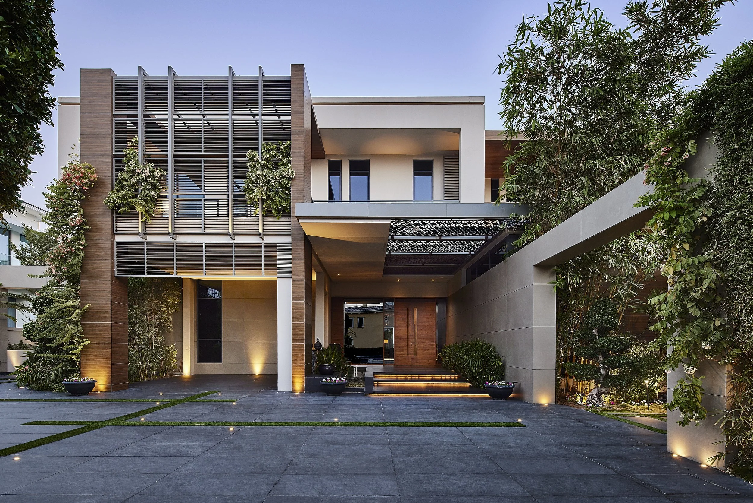 Front facade and entrance of M Villa, Dubai Hills Estate, with climbing plants and a stone forecourt