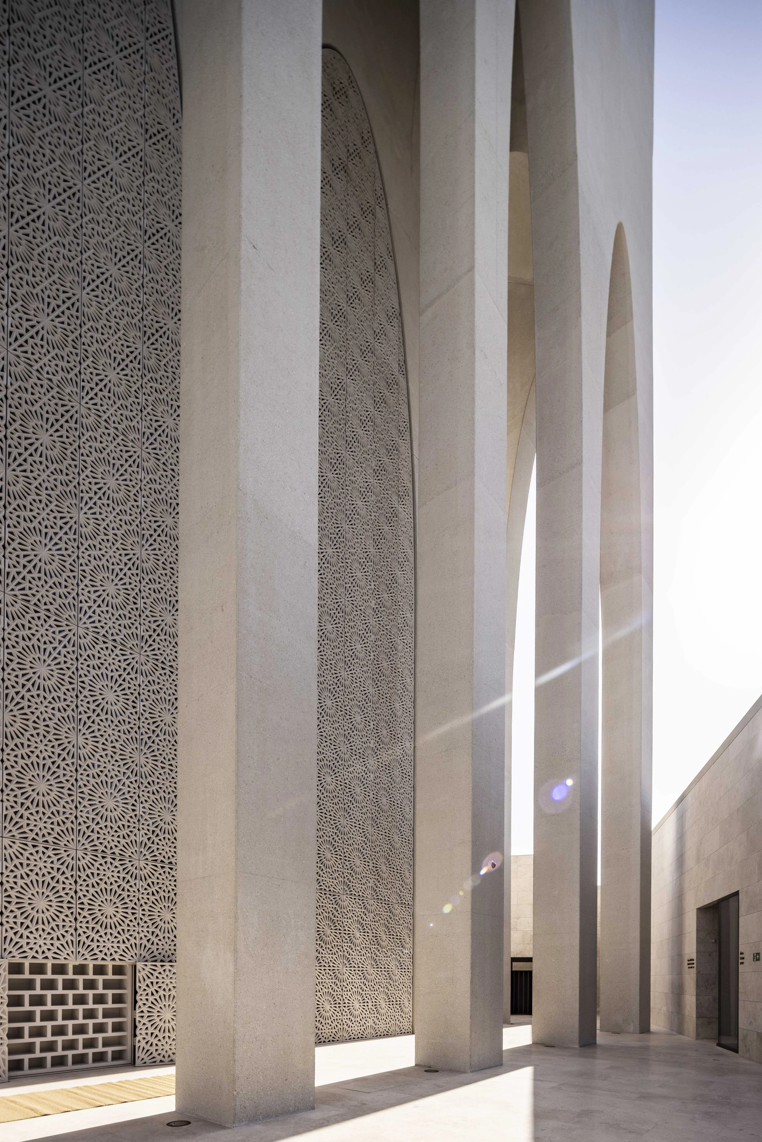 Parabolic arches and lattice screens on the exterior of the Imam Ahmed Al-Tayeb Mosque, Abrahamic Family House, Abu Dhabi. Architect Adjaye Associates