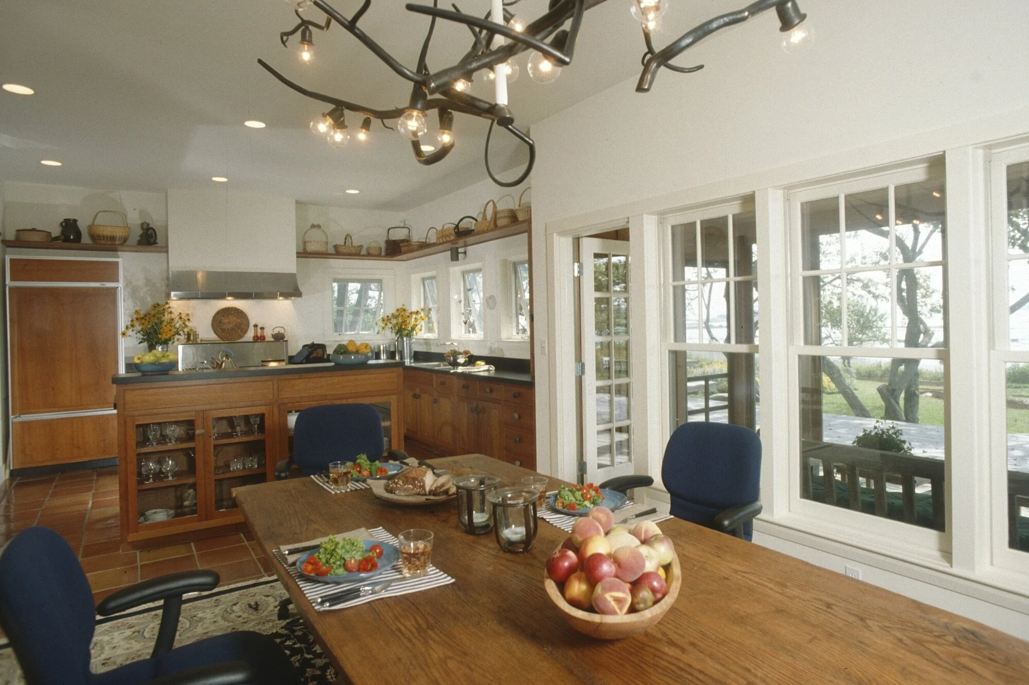 The-kitchen-is-at-the-east-end-the-middle-is-anchored-by-a-handmade-table-with-a-chandelier-designed-by-the-client.jpg