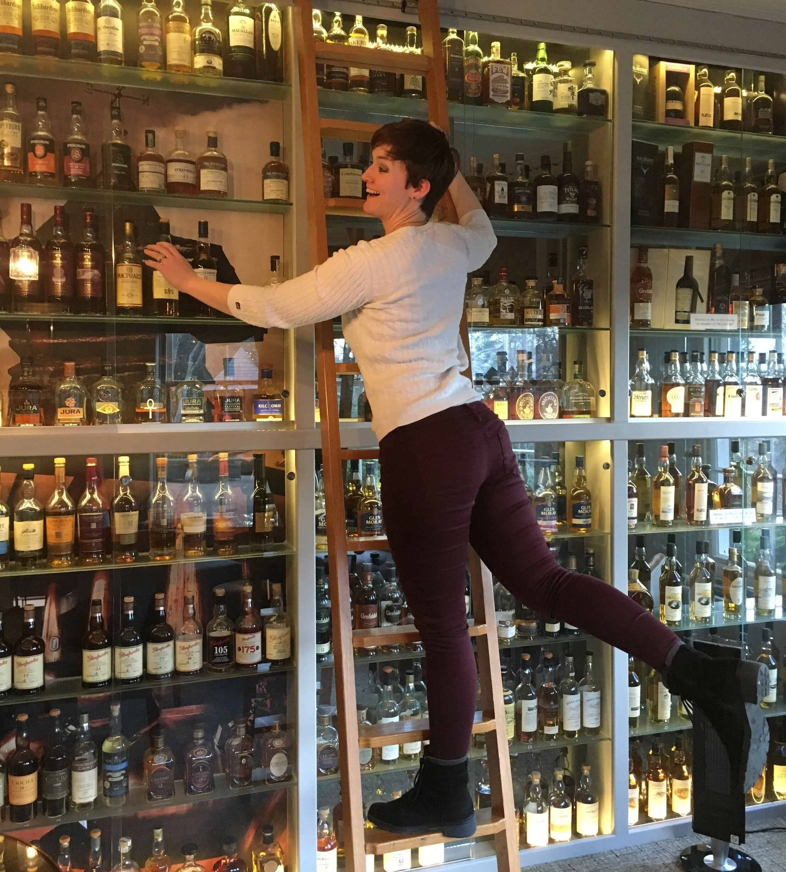 Me reaching for a higher shelf, living out my version of “Beauty and the Beast” with whisk(e)y.
