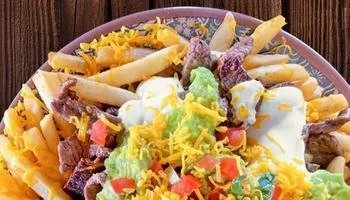 Top Mexican restaurant near La Mesa, CA serving plate of fries with meat, guacamole, sour cream and cheese.