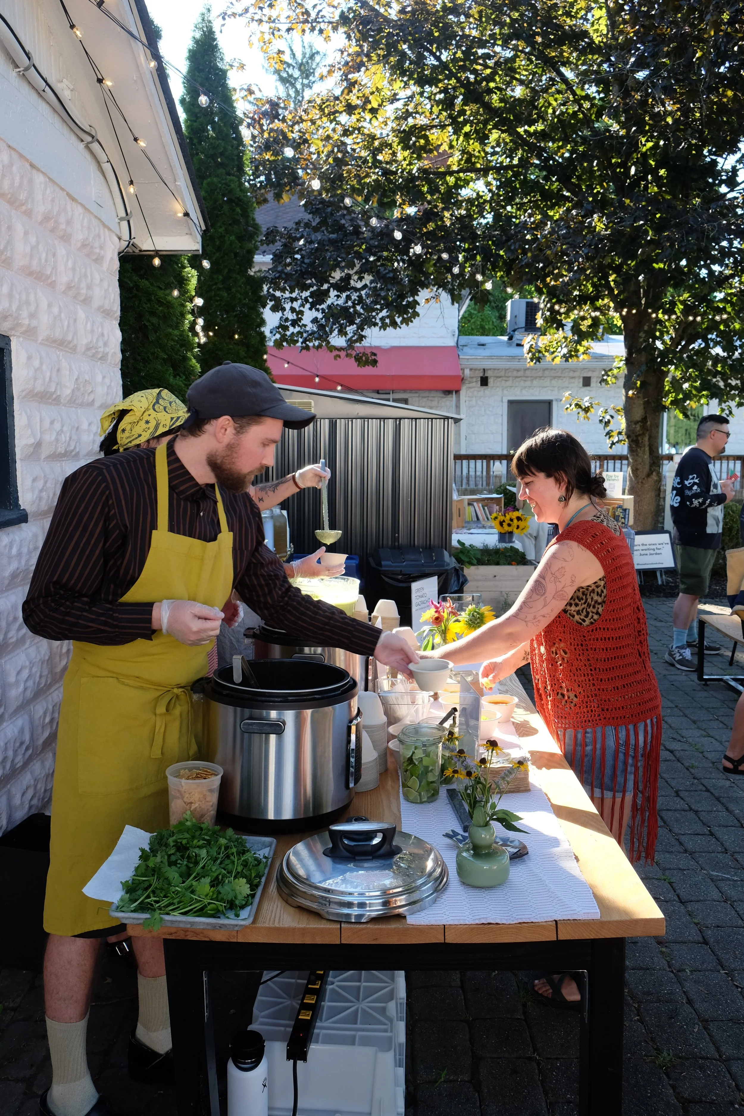 Chef serving soup outside on a sunny day