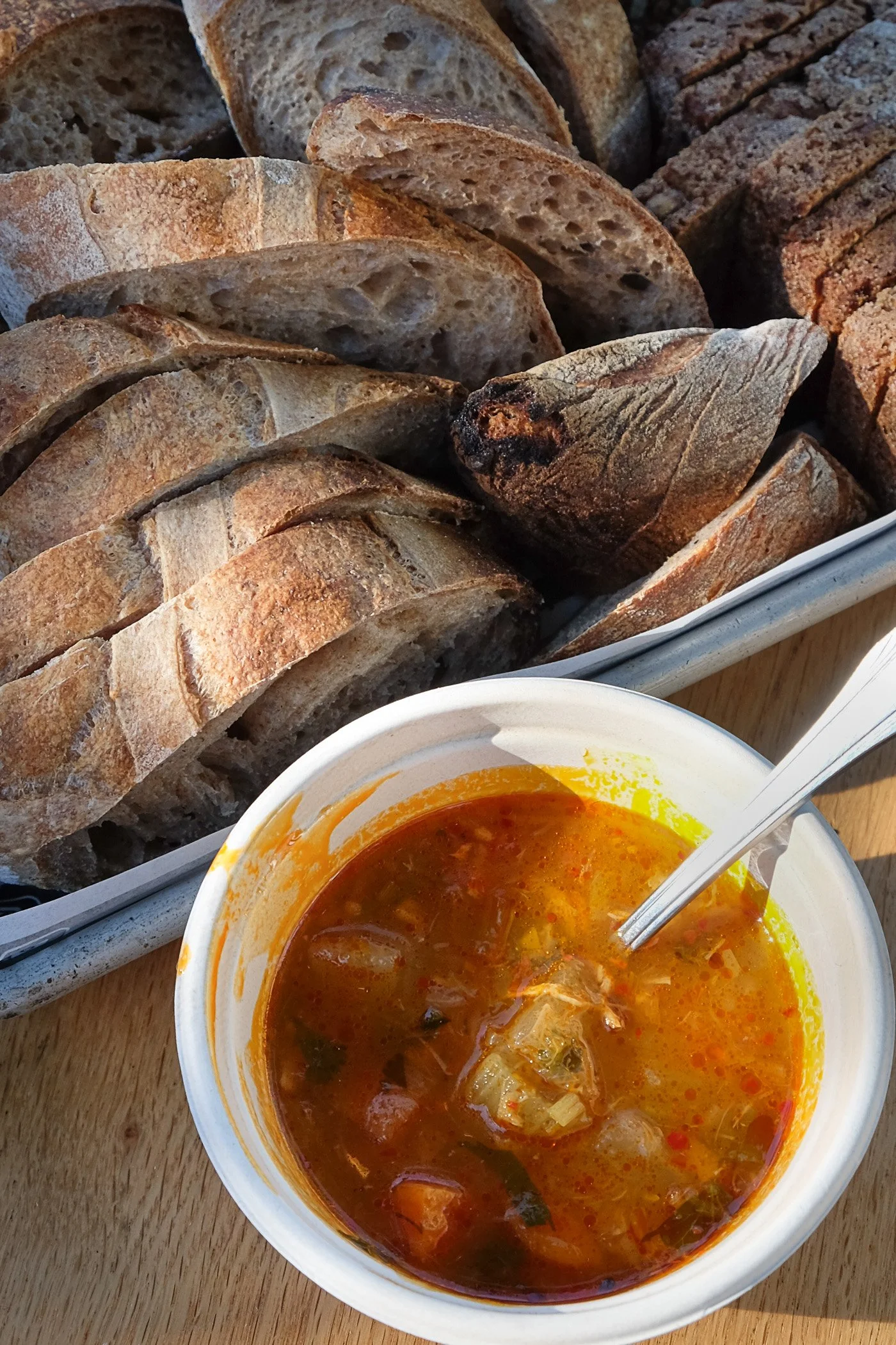 A bowl of red soup with bread