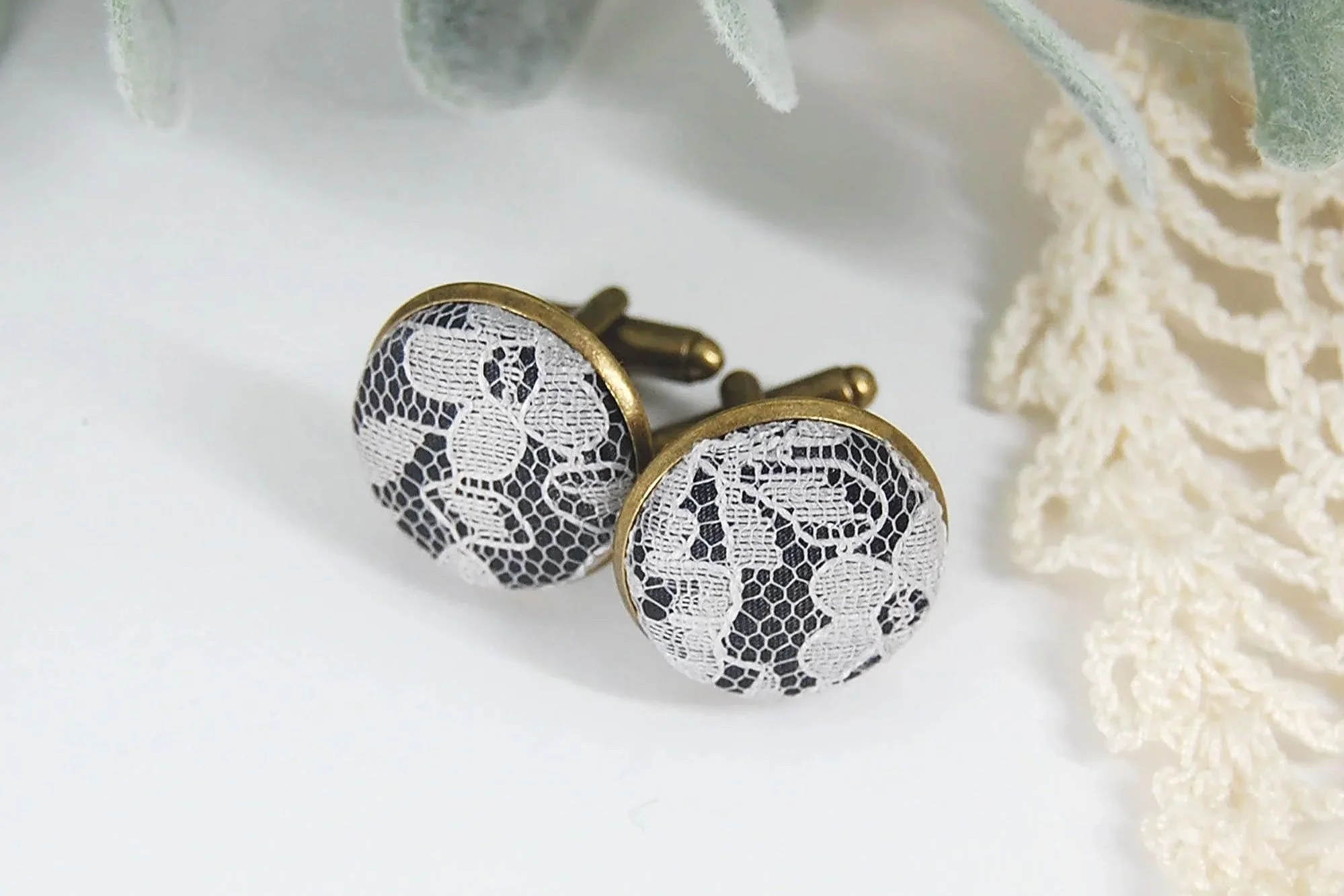 White lace cufflinks with black background and bronze settings