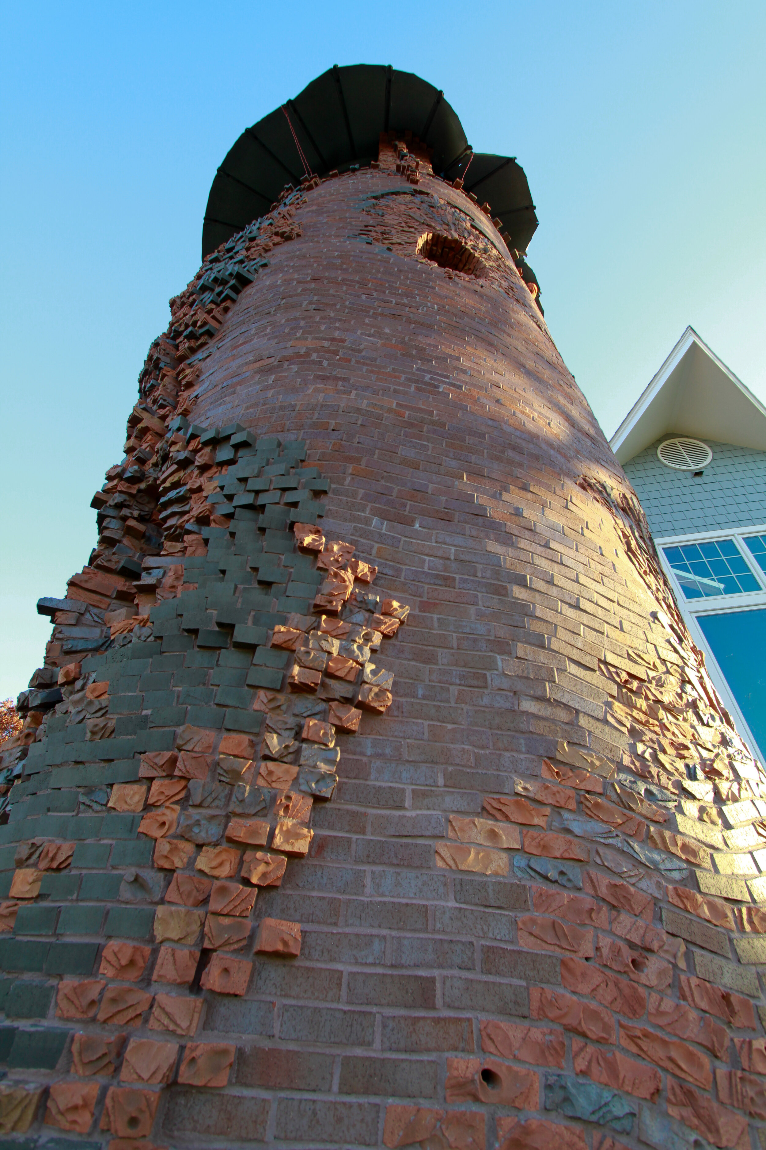 textured, carved  brickwork adorns the side of silo