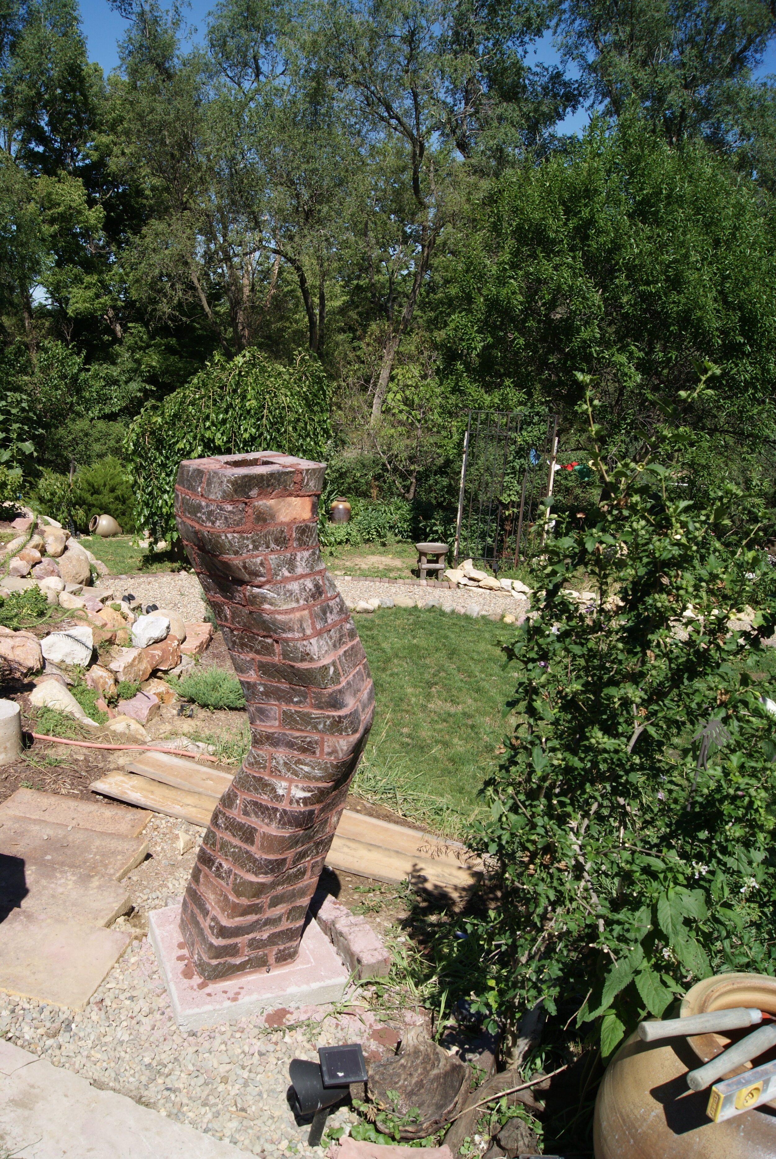Carved brick column in garden by Michael Morgan
