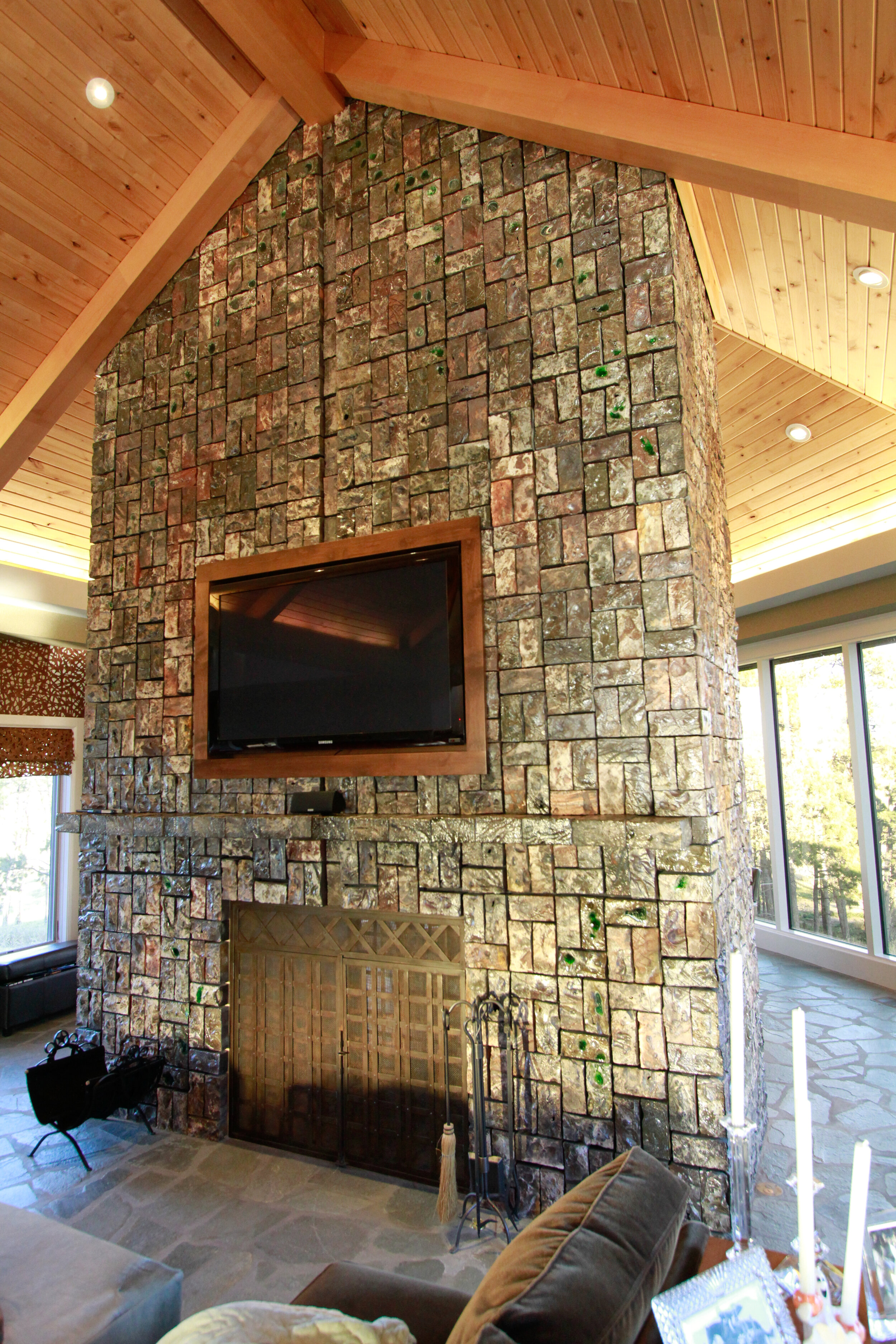 Carved and salt glazed bricks create an iridescent surface for this cathedral ceiling height fireplace in Nashville, NE