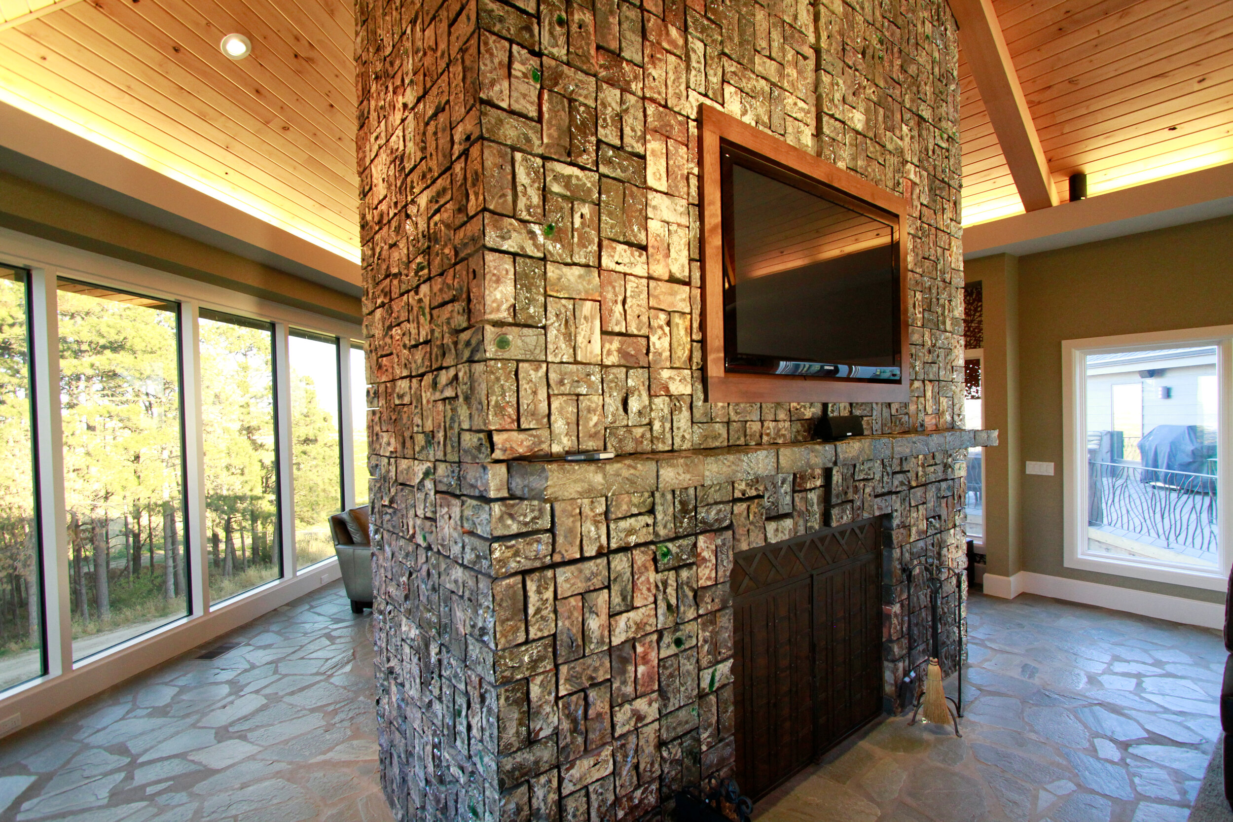 Carved and salt glazed bricks create an iridescent surface for this cathedral ceiling height fireplace in Nashville, NE