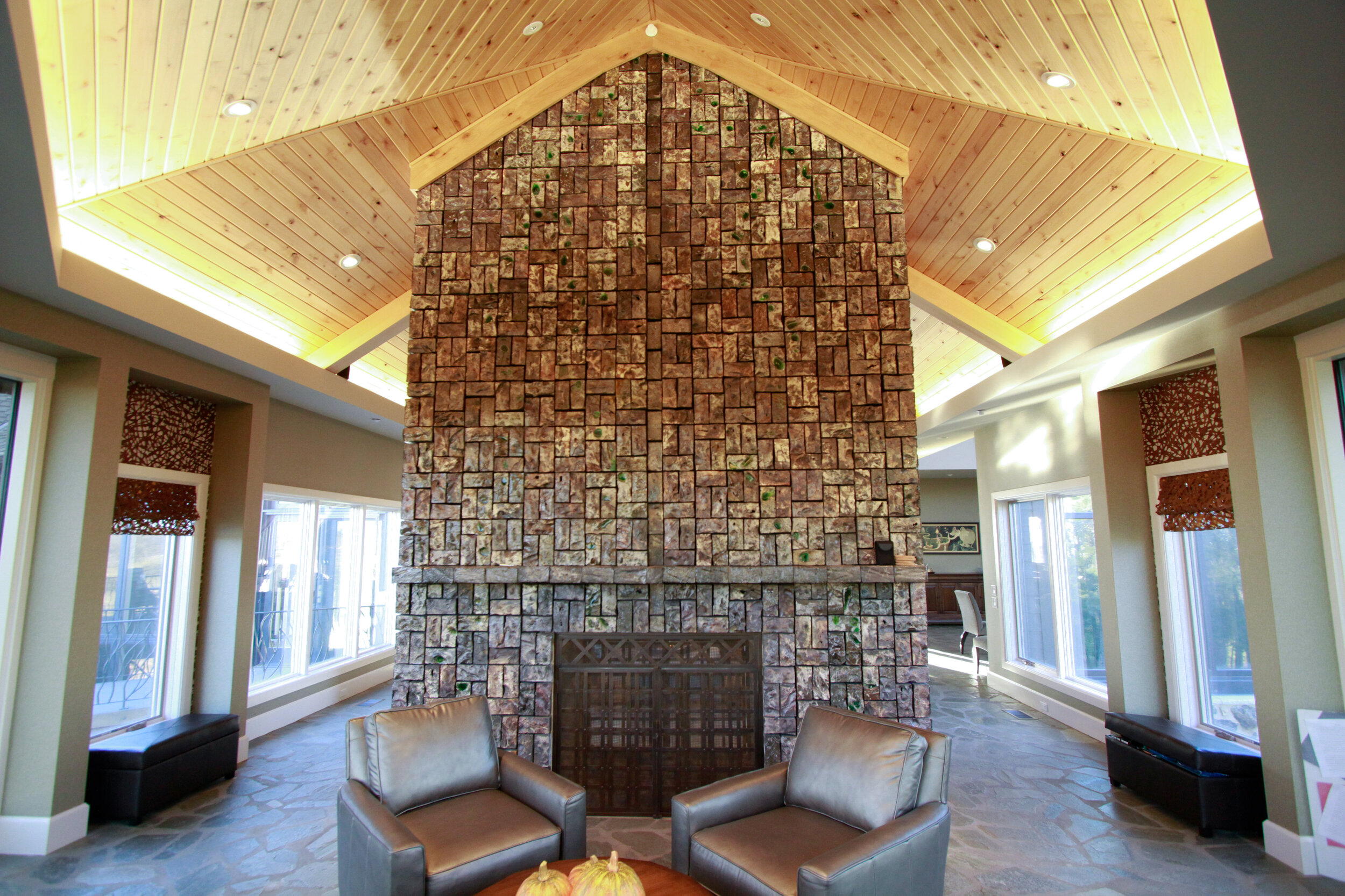 Carved and salt glazed bricks create an iridescent surface for this cathedral ceiling height fireplace in Nashville, NE