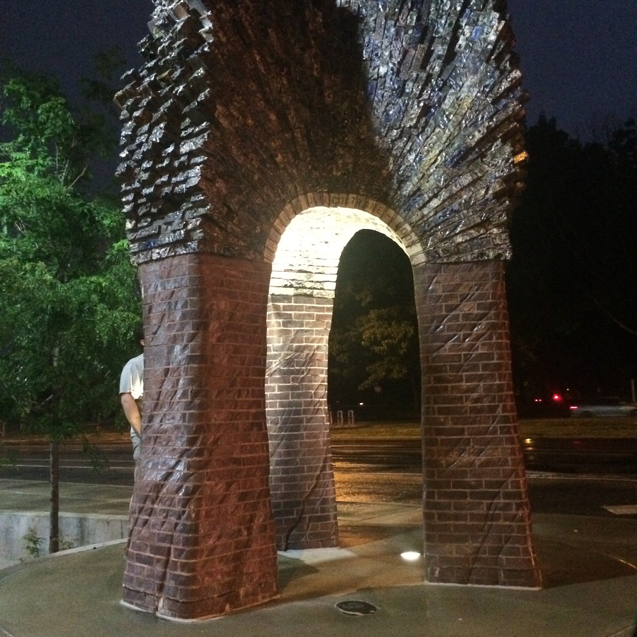 Arches of Resurgence , three legged carved brick arch, lit at night 