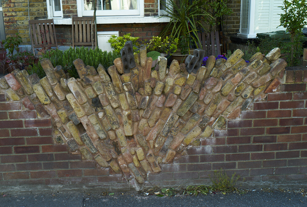 Garden wall of river washed bricks from the Thames, London.