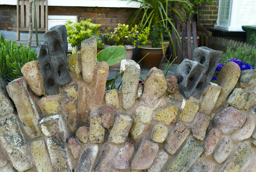 Garden wall of river washed bricks from the Thames, London.