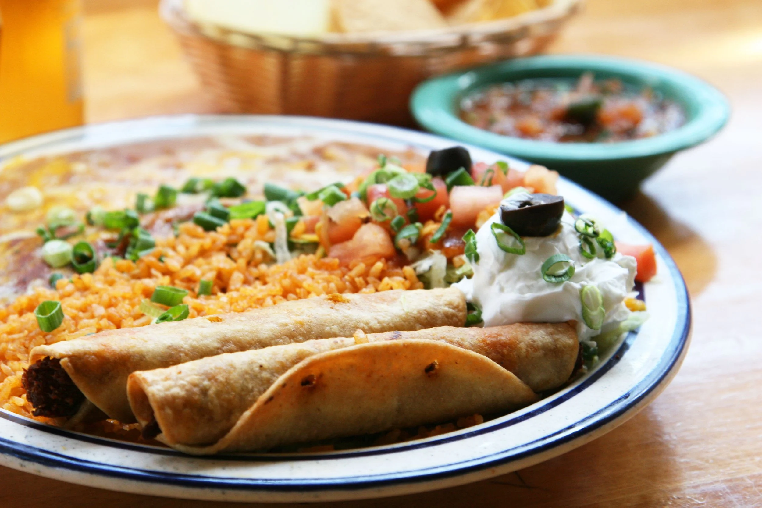 Taquitos plate complete with beans, rice, and salsa