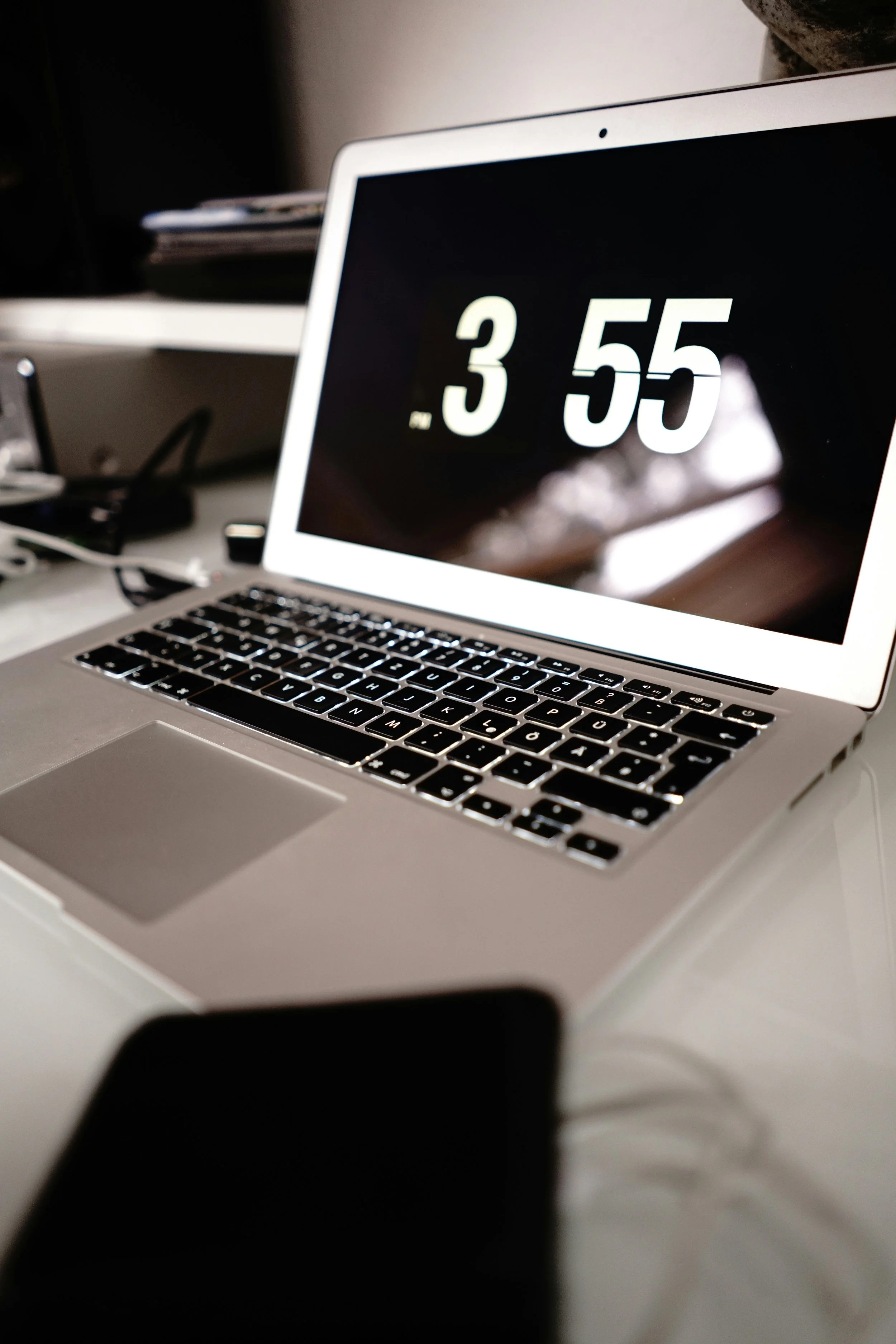 A laptop showing the time as 5 minutes to 4pm