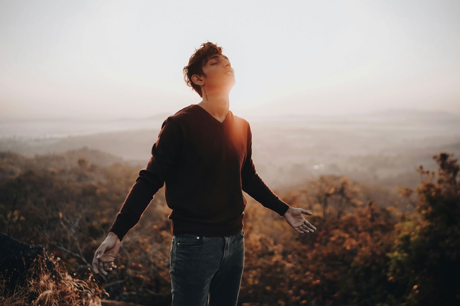 Man breathing deeply on a bright hillside