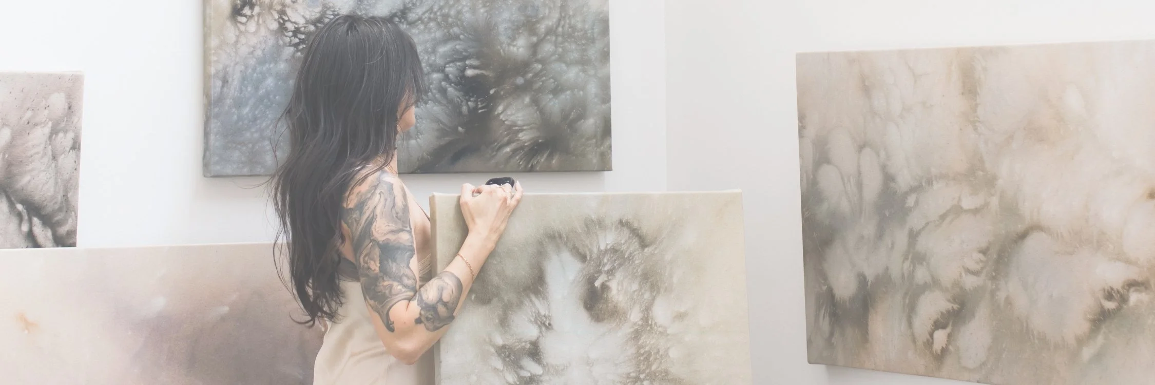 A beautiful, exciting emerging artist standing in her studio in front of her abstract art paintings in Columbus, Ohio at the 400 West Rich Galleries