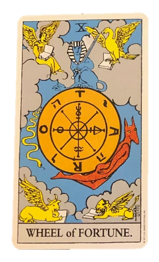 Image provided by Hetty Roi. Alt text: A yellow wheel floats against a blue sky and four clouds. On each cloud sits a winged creature reading a book. On the wheel sits a Sphinx, a snake and a red Anubis. The bottom of the card reads ‘WHEEL OF FORTUN…