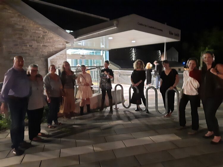 Captions: the audience communes outside during intermission jovially connecting over their shared histories in Kingston.