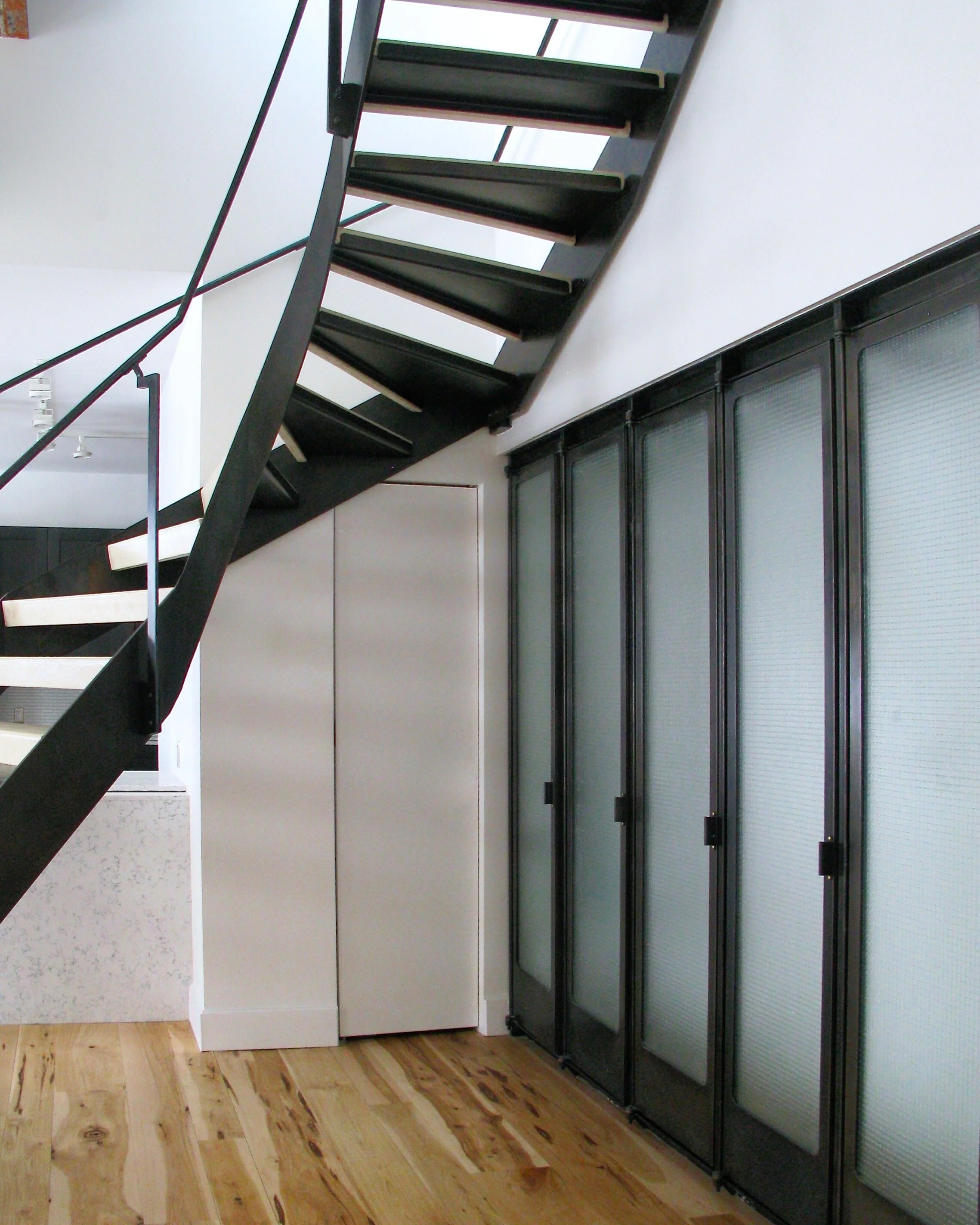 Winding steel frame stair and hand rail, with concrete treads.
