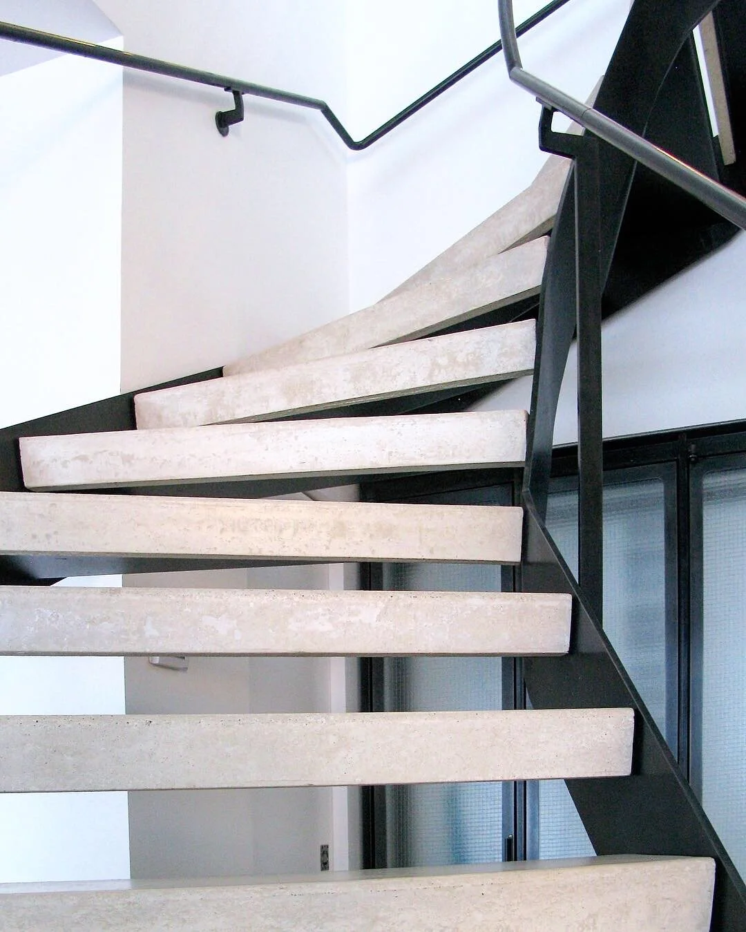 Winding steel frame stair and hand rail, with concrete treads.