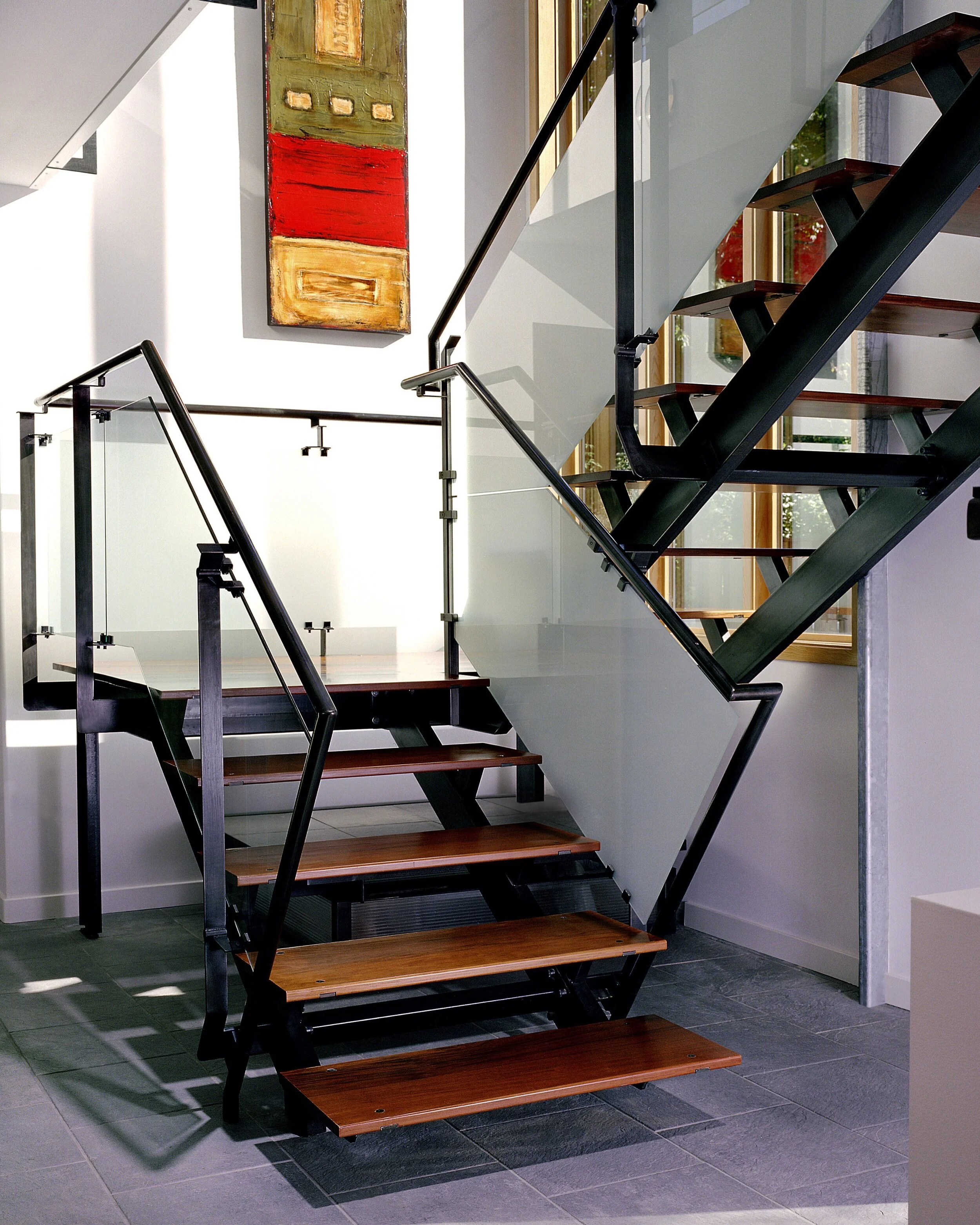 Steel switchback stair and handrail, glass infill and wood treads