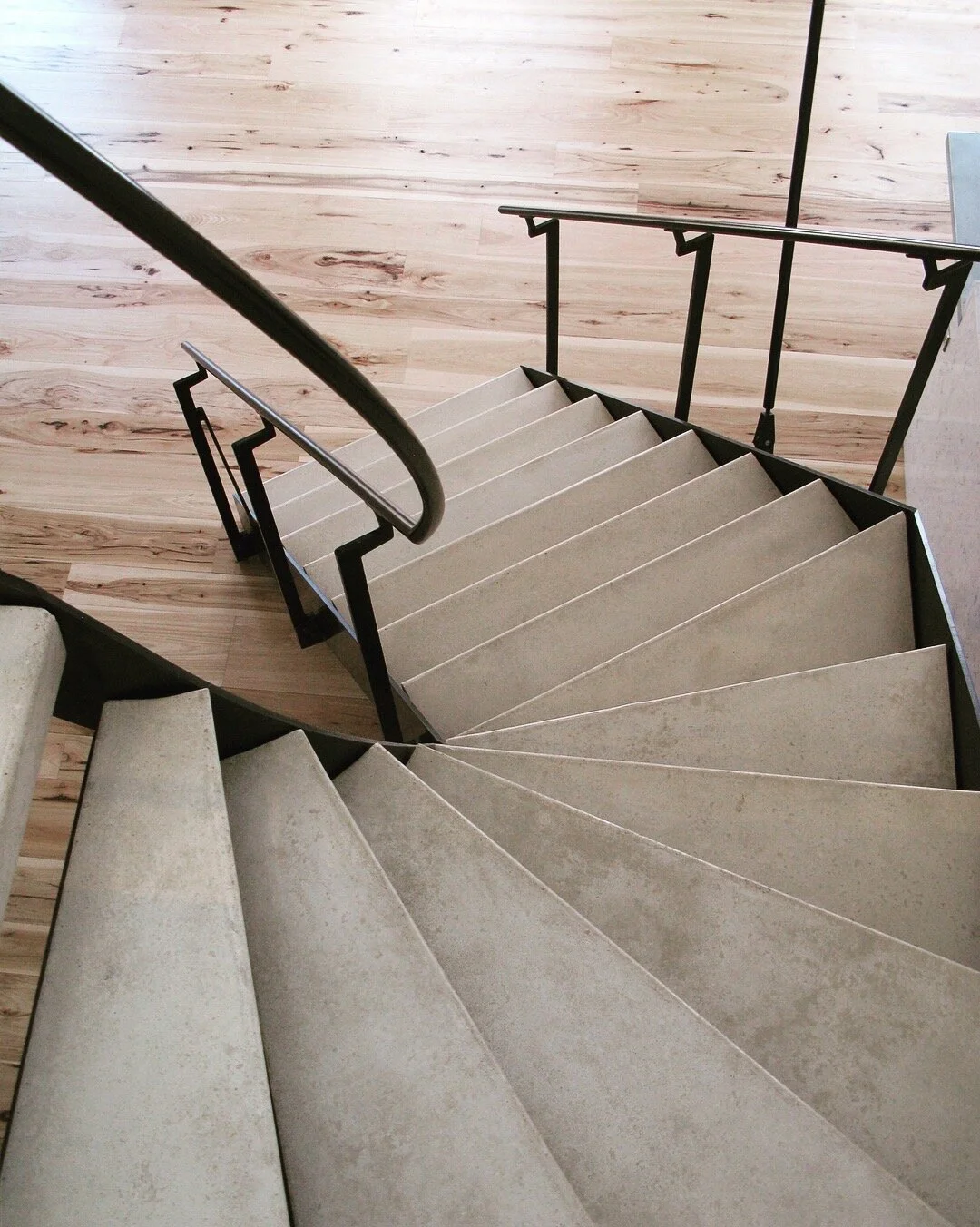 Winding steel frame stair and hand rail, with concrete treads.