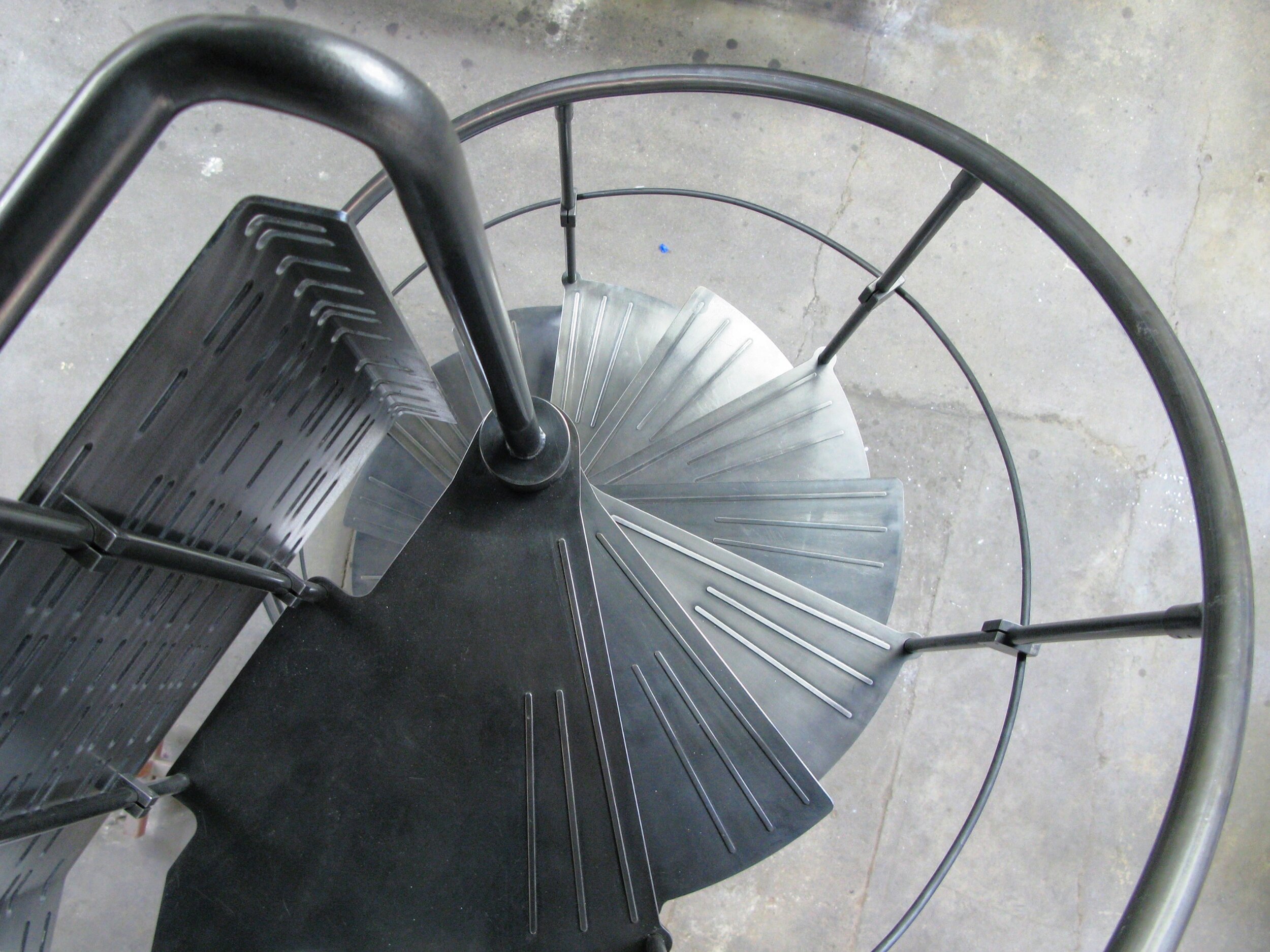 Steel spiral stair with handrail.  machined steel treads