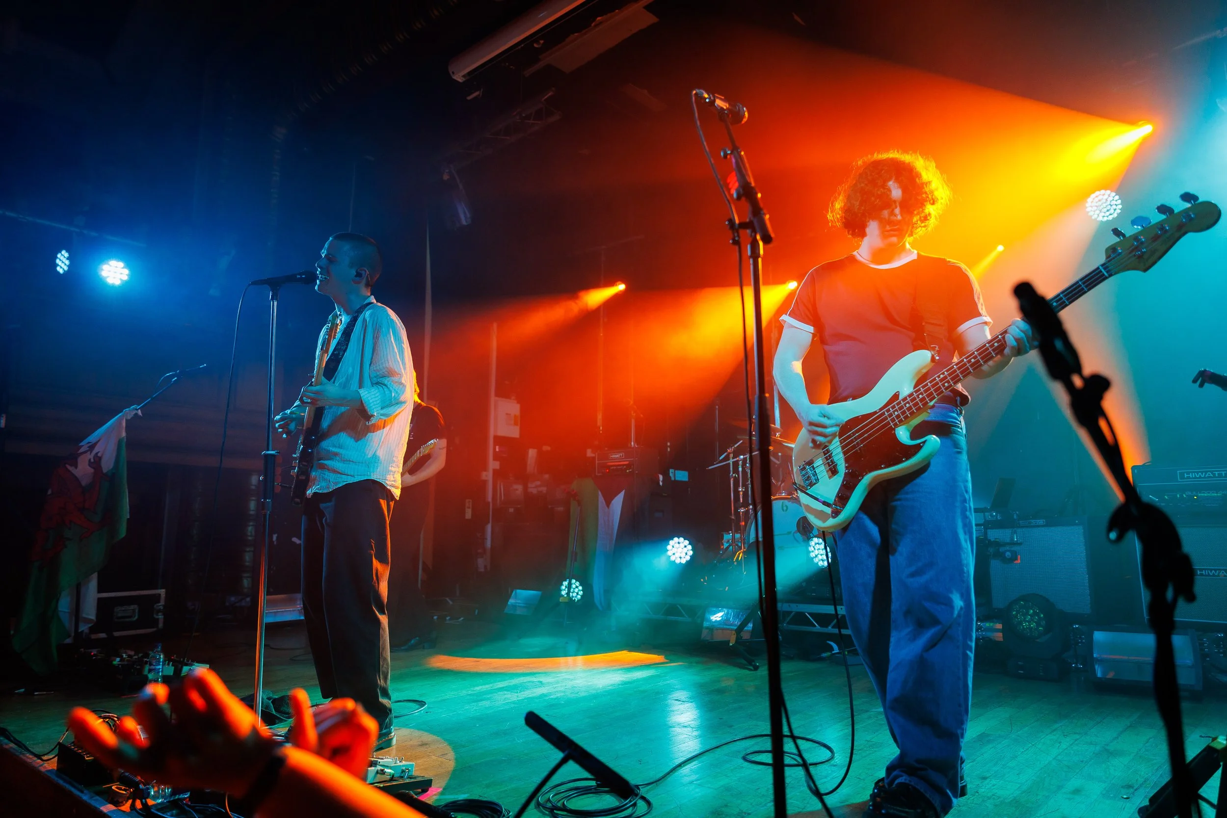 Band performing live on stage with blue and orange stage lights.
