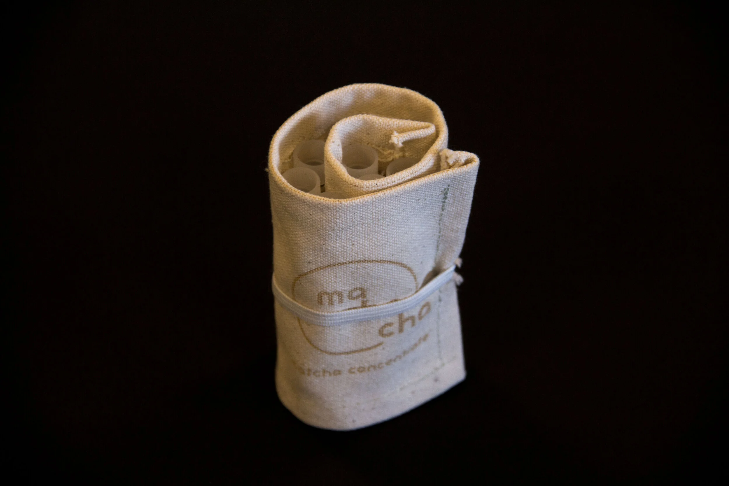  The compact roll is secured with a band sewn into the seam. This package is hand made using canvas and plastic vials.  