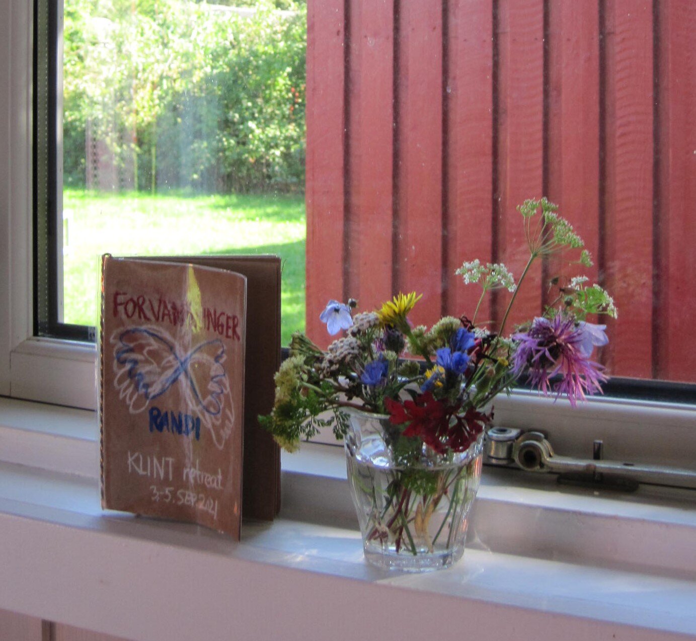 blomster og notesbog i vindue.jpg