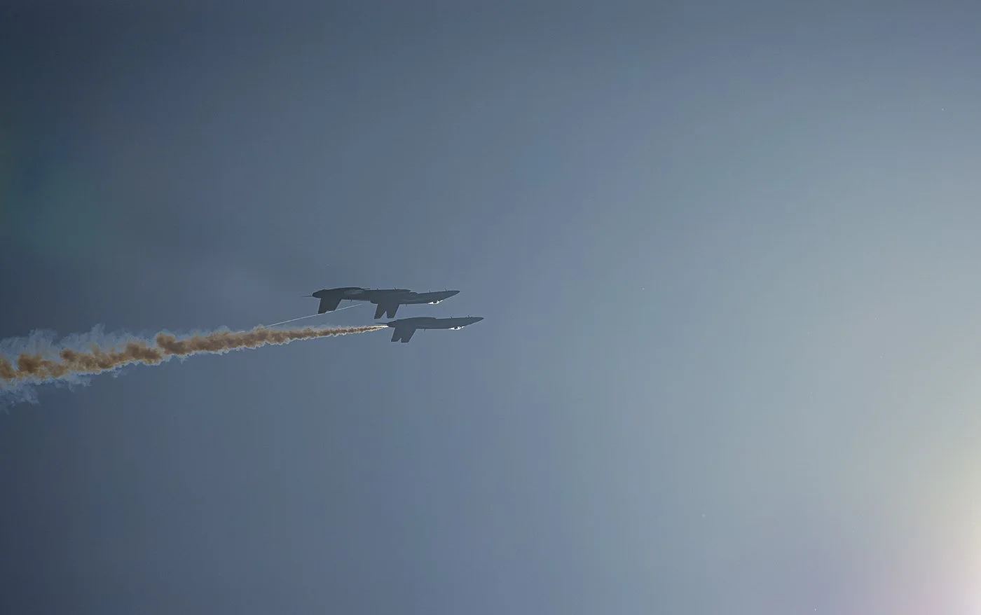 Three Blue Angel F18's flying inverted towards the sun at the Thunder Over New Hampshire air show